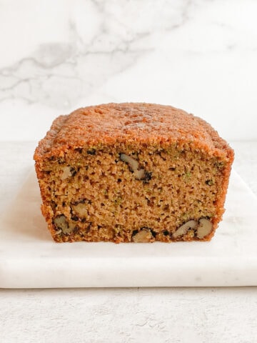 Front shot of gluten-free zucchini walnut bread, sliced open front to see the walnuts on the inside.
