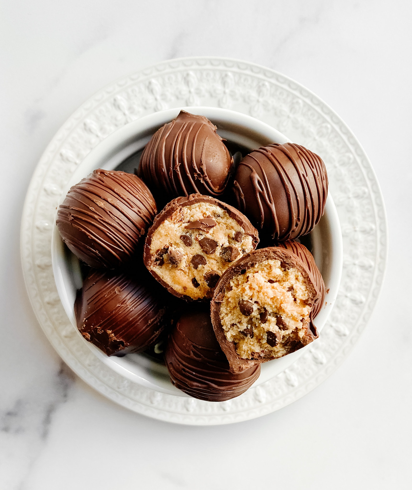 Gluten-free cookie dough truffles on a small plate aerial view cut open at the top of the pile.