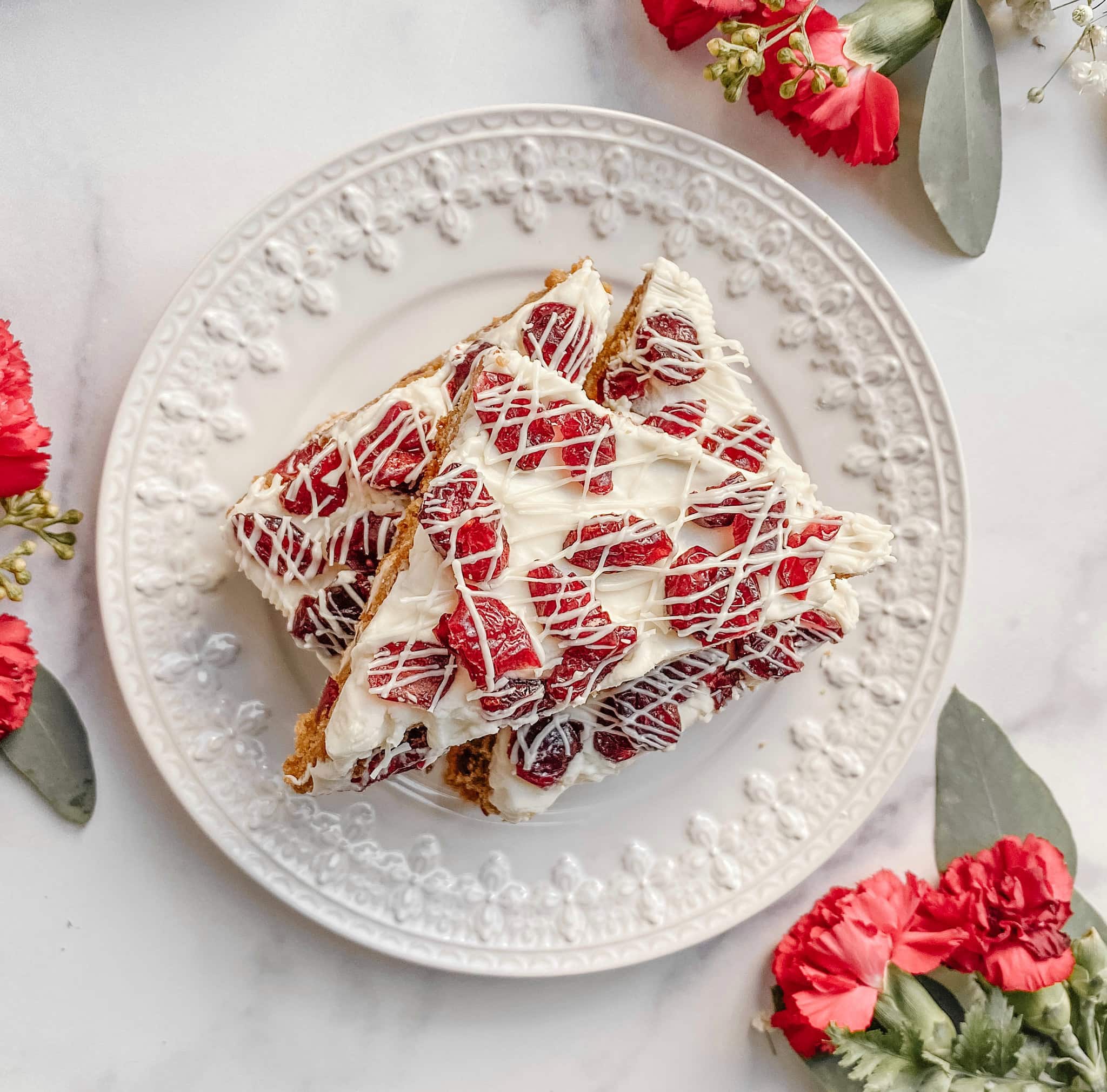 A stack of cranberry bliss bars on a decorative ceramic plate.