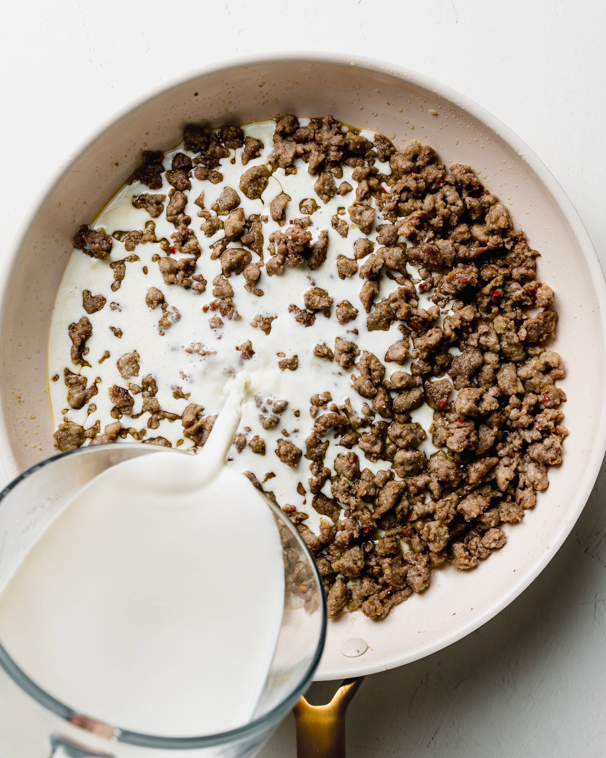 Pour the milk into the ground sausage.