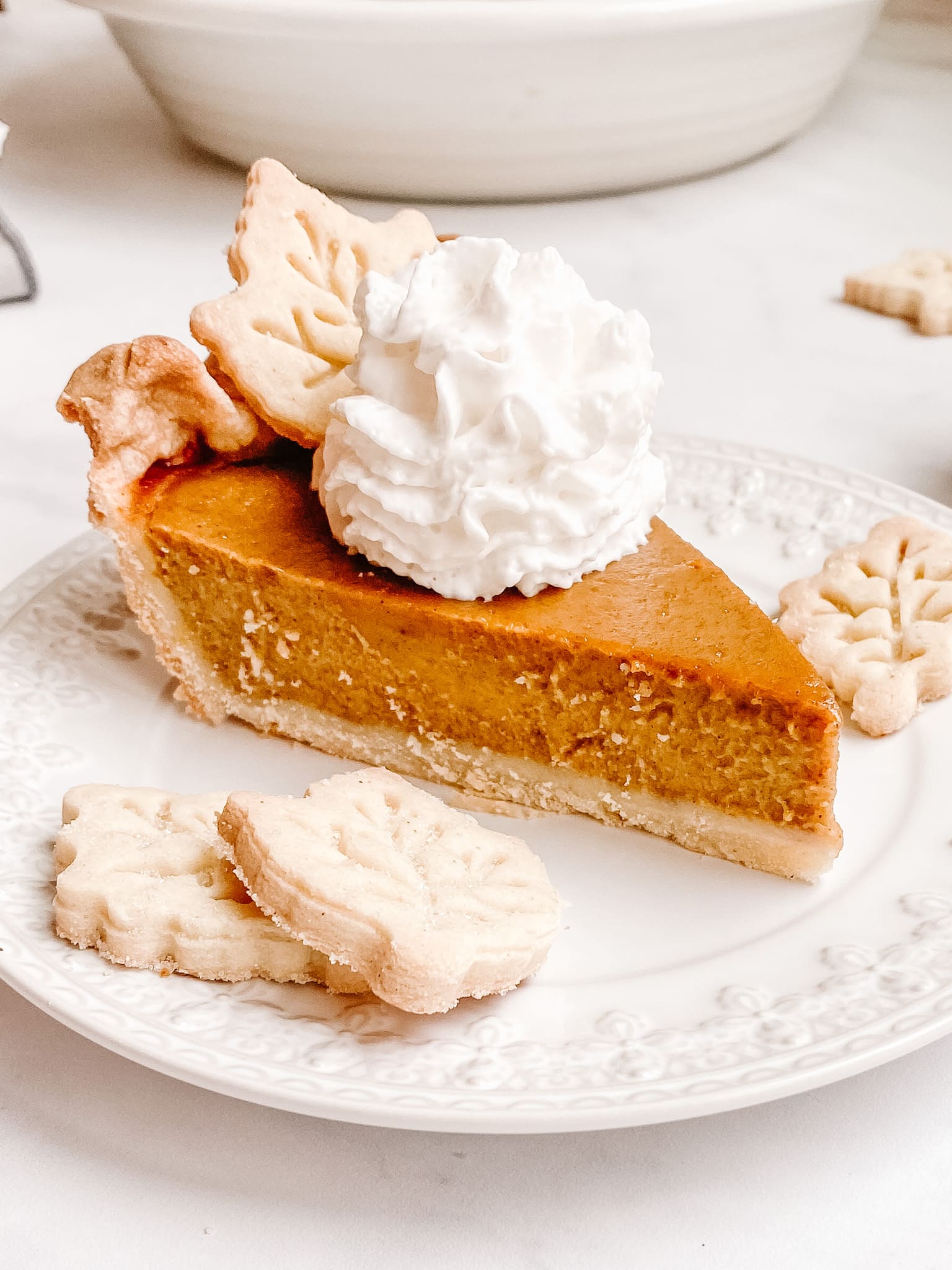 gluten free pumpkin pie with pastry leaves and whipped cream