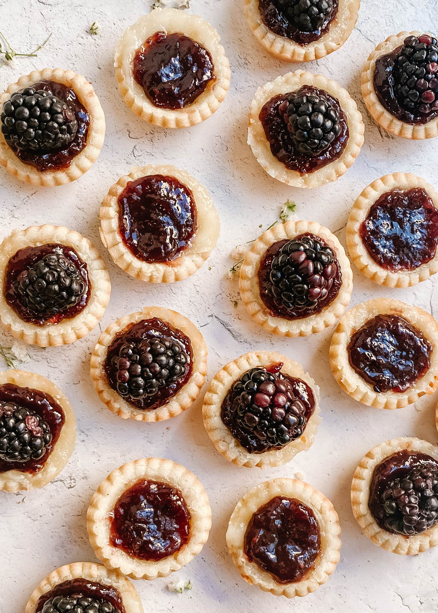 gluten-free blackberry brie tarts on a marble back drop 