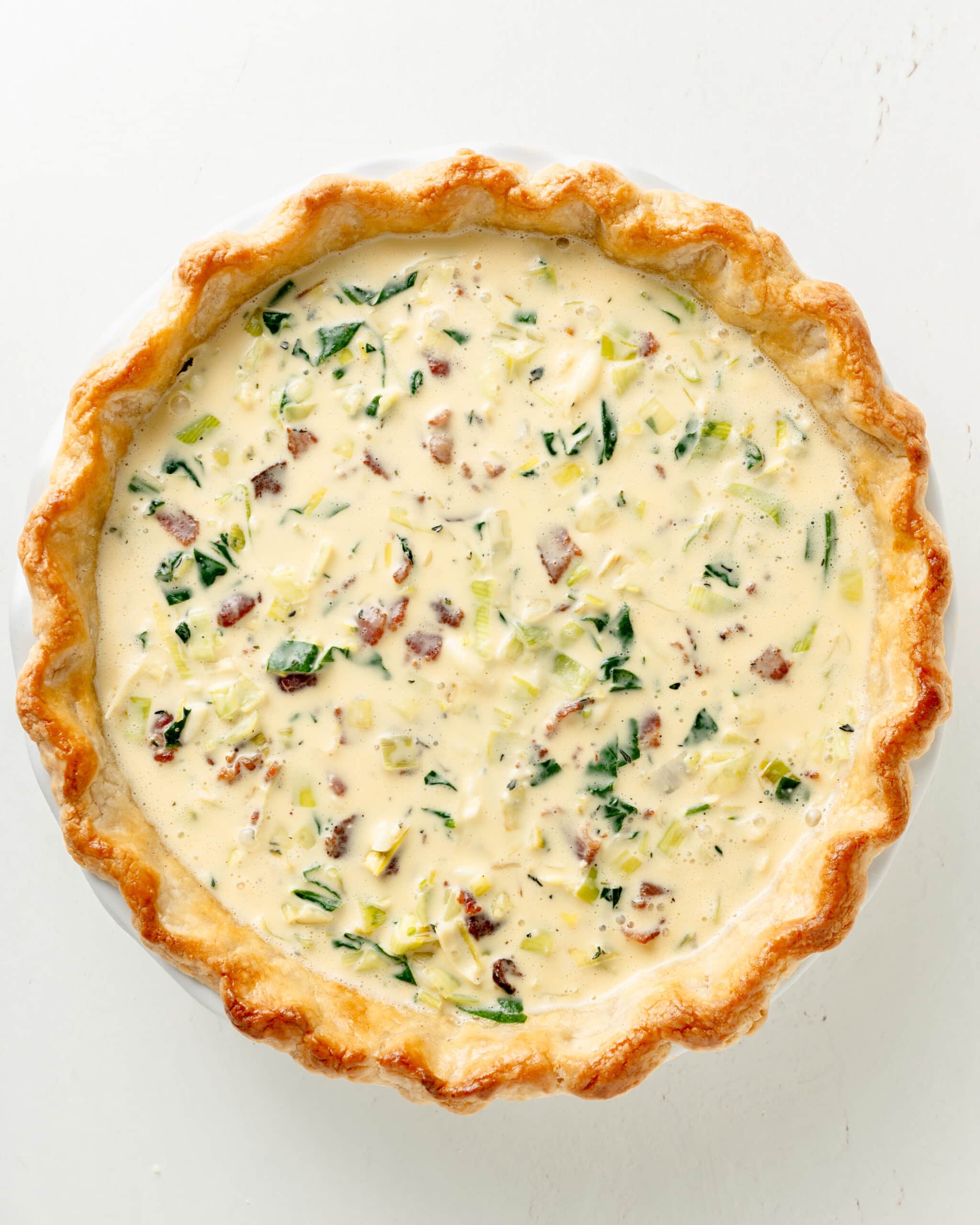 Gluten Free Bacon Spinach and Leek Quiche filling prior to baking.