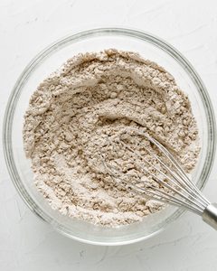 Gluten-Free Zucchini Bread Dry Ingredients in a Large Clear Bowl Being Whisked.