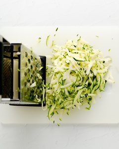 Zucchini being grated with a box grated.