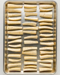 Add the coated parsnips to a baking sheet and roast until golden brown.