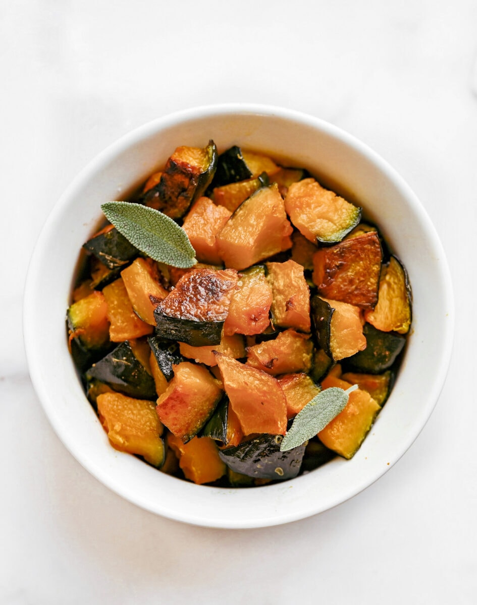 Roasted Kabocha squash cooked in a white ceramic dish.