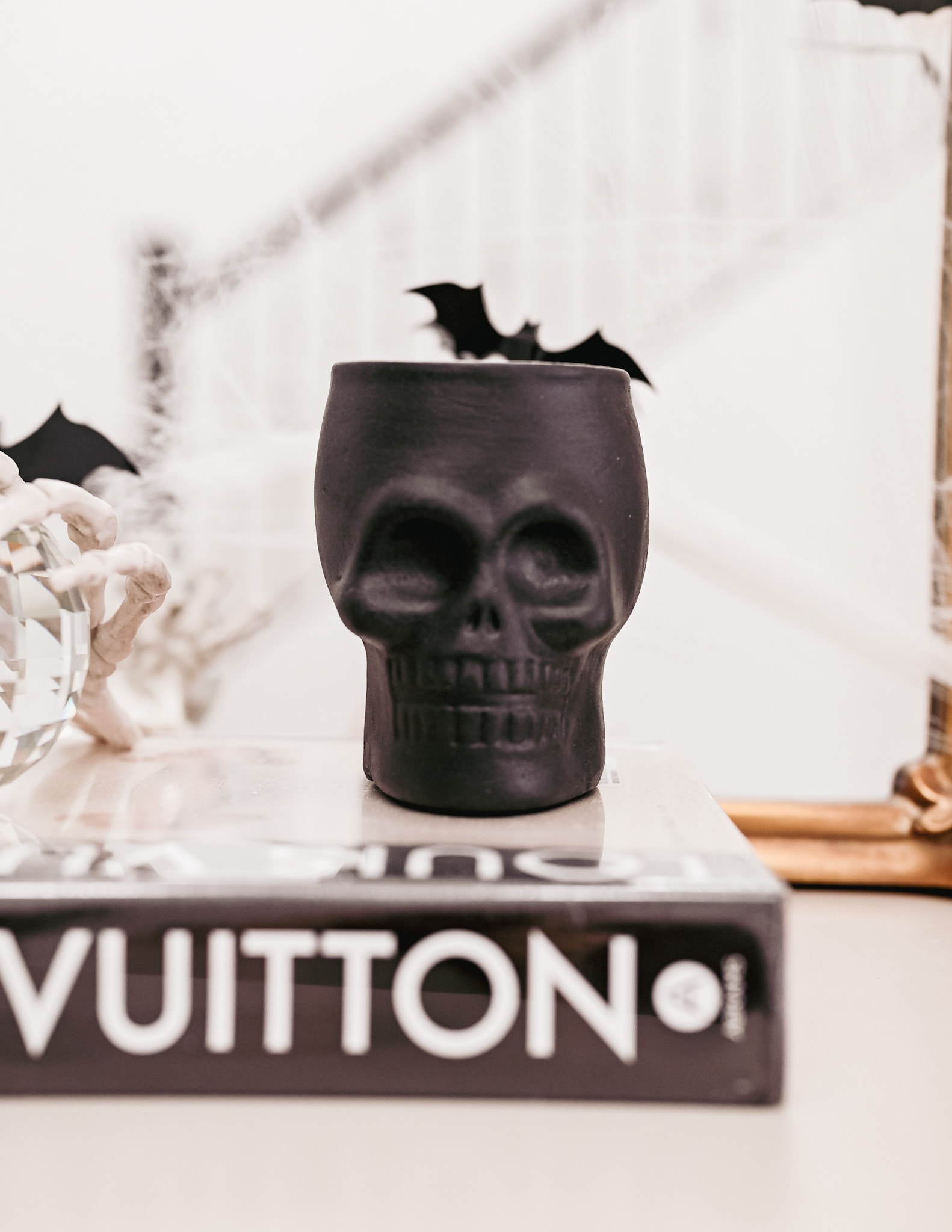 black skull ceramic sitting on a Louis Vuitton book