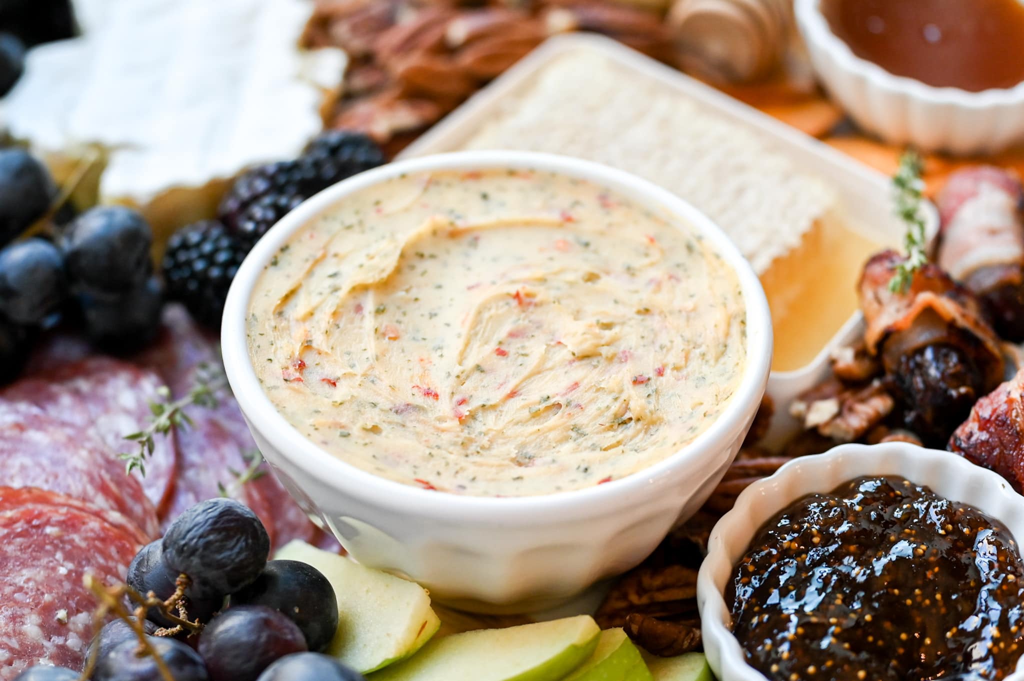 hot pepper cheese dip in a white bowl, in the center of the charcuterie board