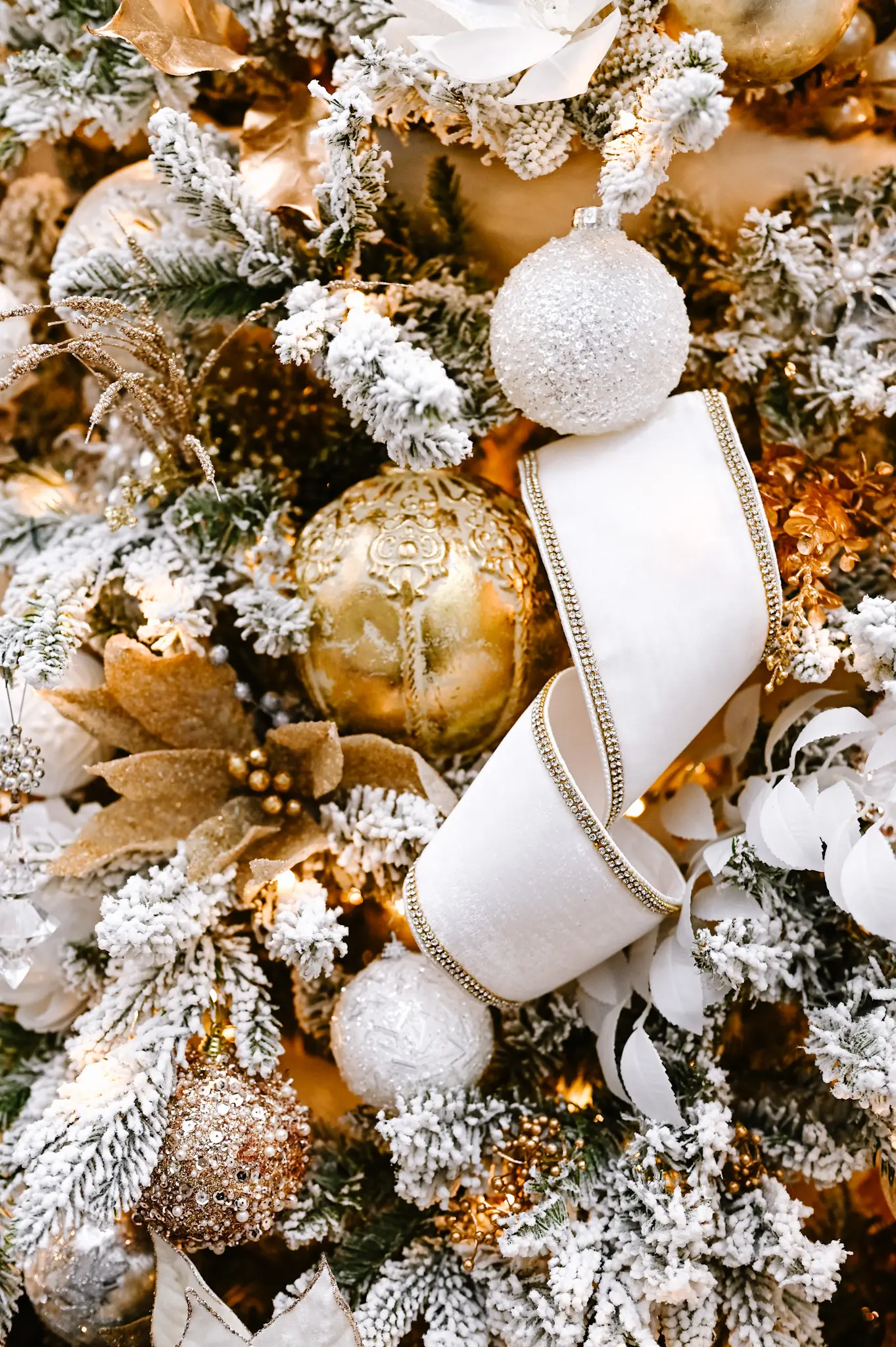 various gold, white and silver ornaments next to a white felt ribbon