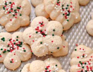 pile of white gluten-free spritz cookies with red, white, and green colored sprinkles