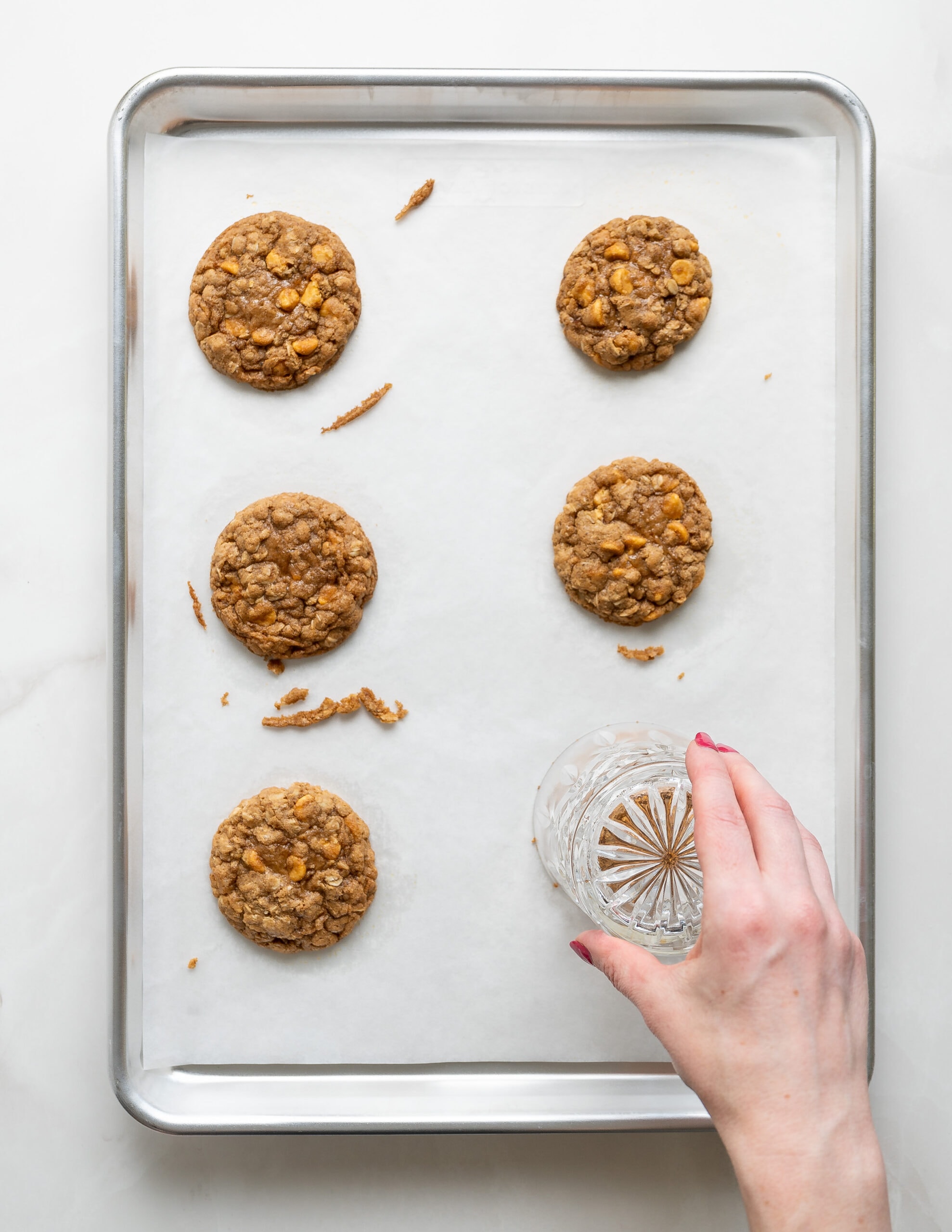 Baked butterscotch oatmeal cookies with a clear glass over the top, rounding out the cookies to a circular form. 