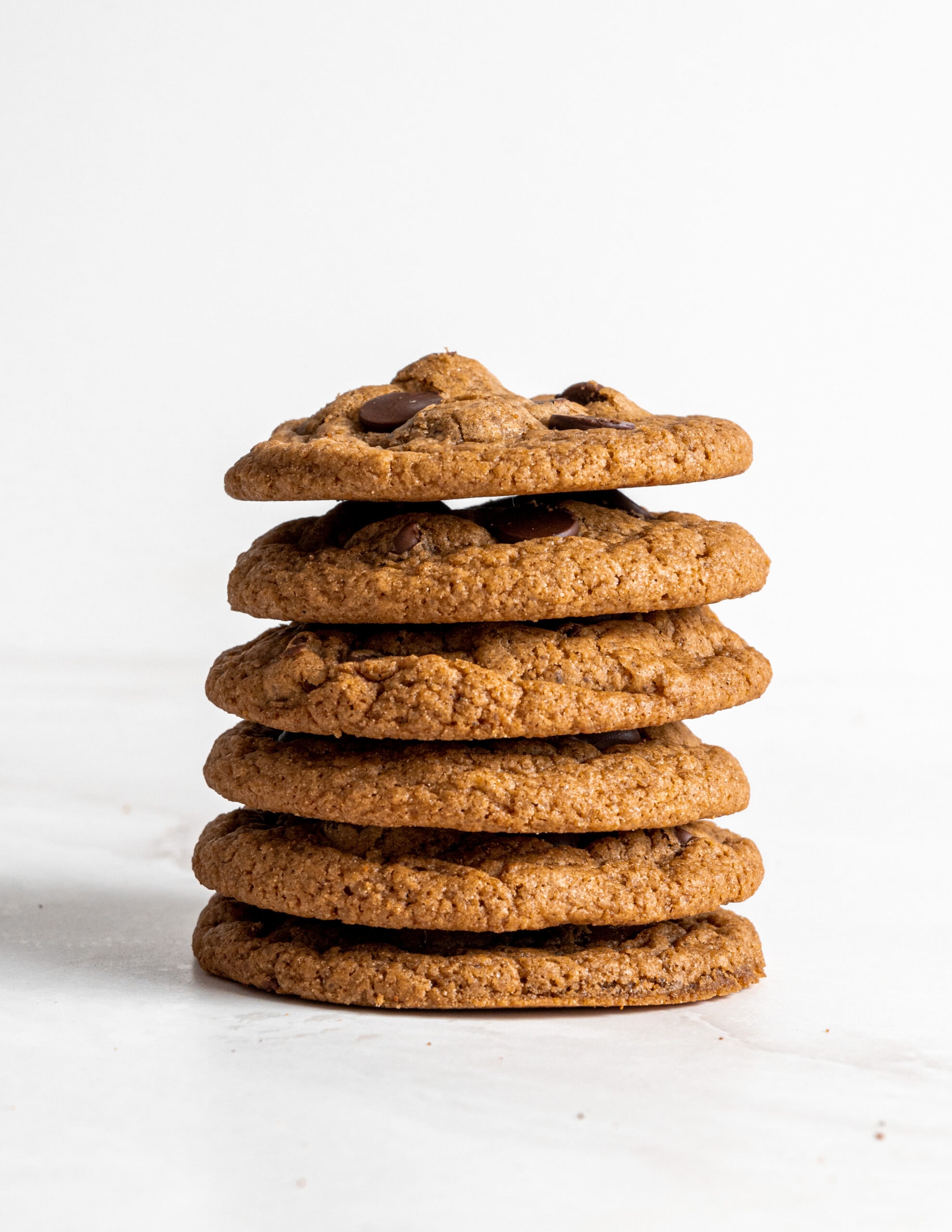 Six stacked pumpkin chocolate chip cookies. 