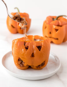 Stuffed pepper with a fork pulling out beef and cheese.