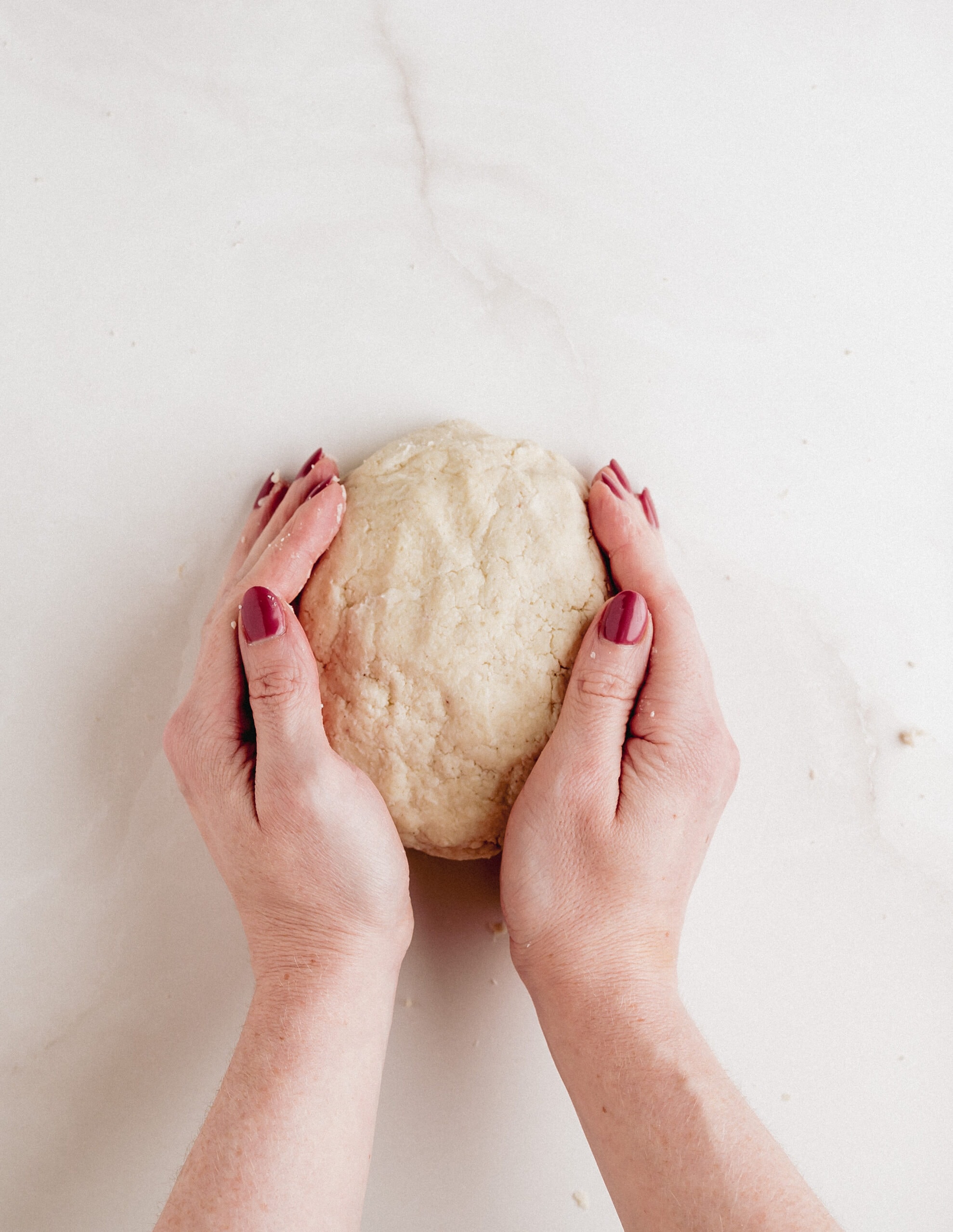 A large mound of pastry dough molded together with two hands.