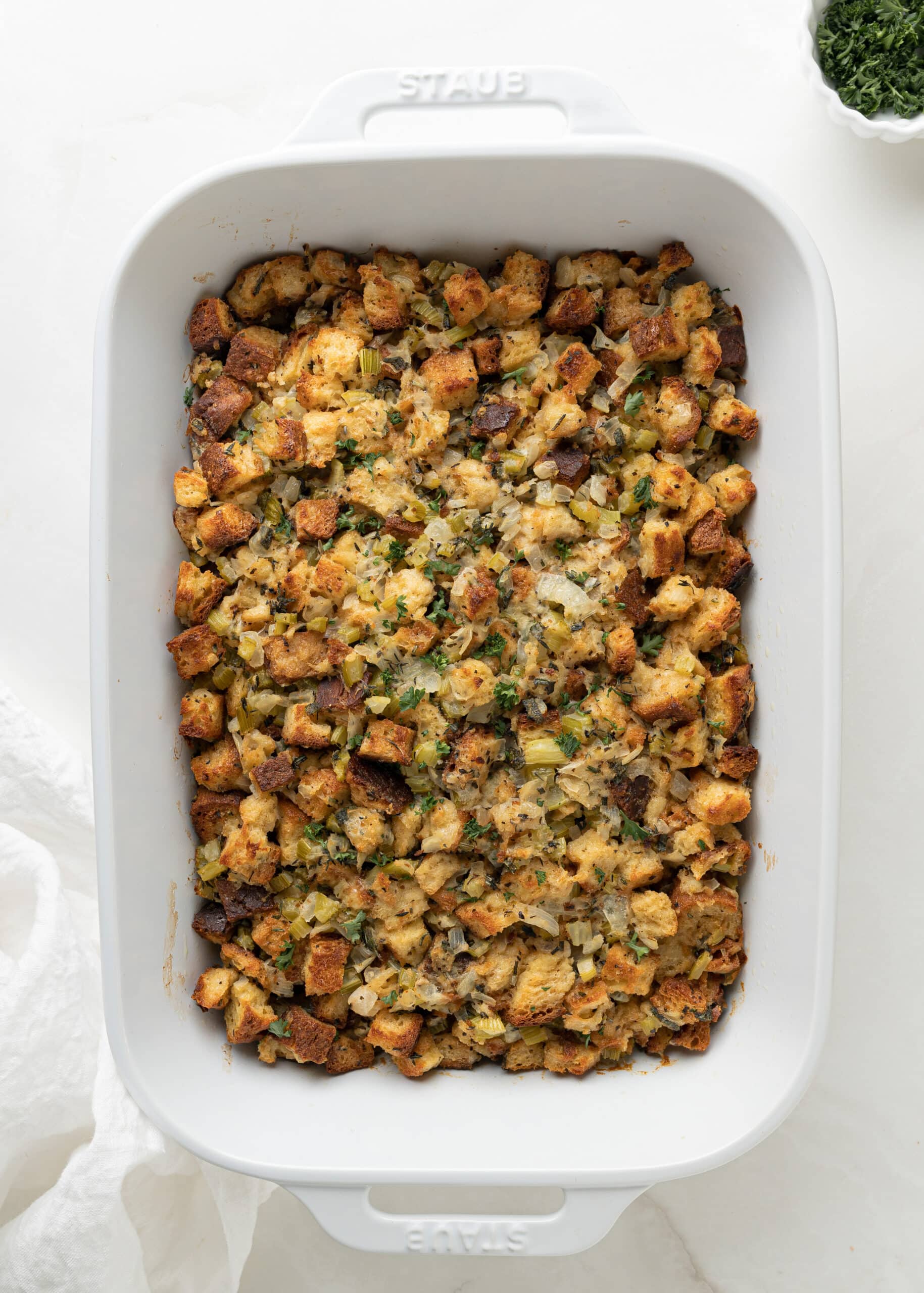 A large white ceramic baking dish with fully baked gluten-free stuffing.