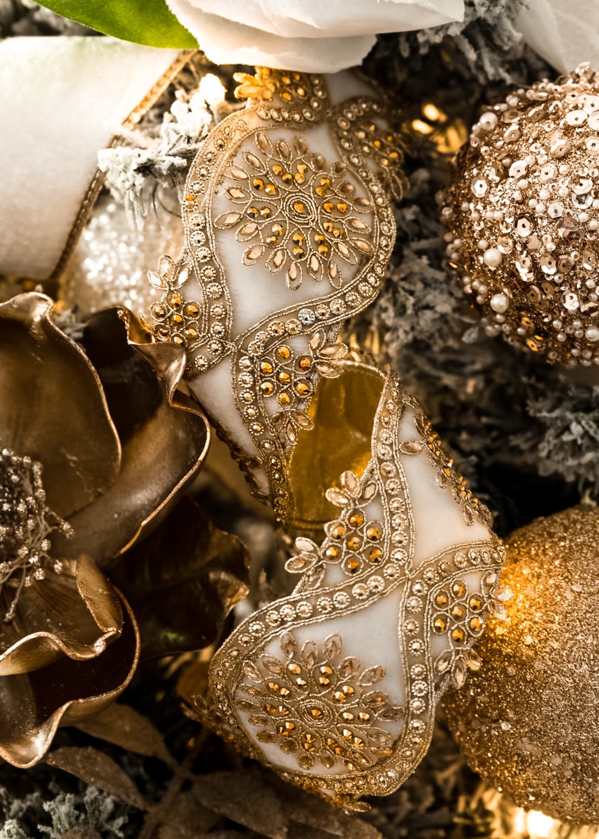 A large view or white and gold decorative jeweled christmas ribbon.