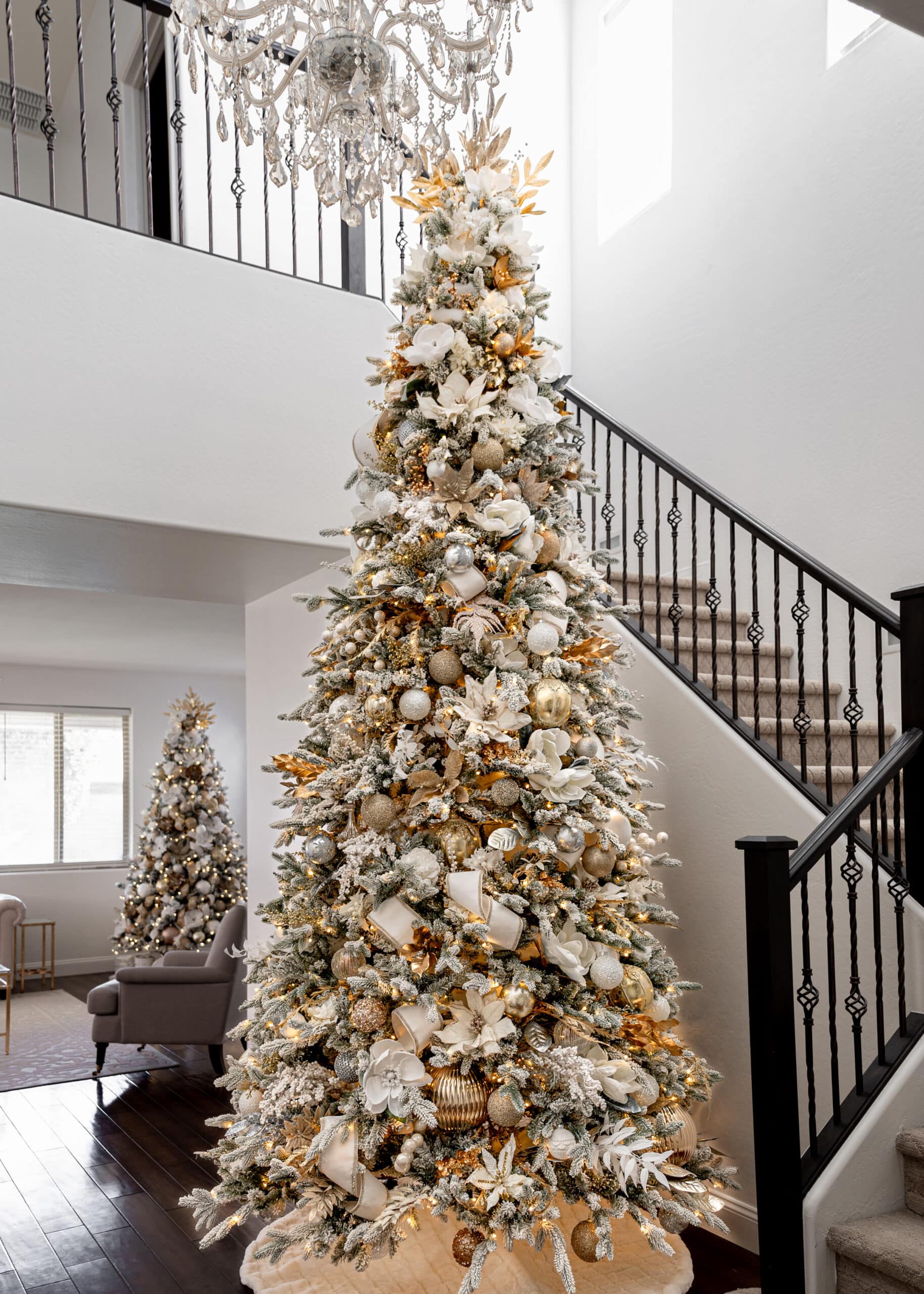 A white and gold christmas tree with white florals, gold florals, white ornaments and gold ornaments. 