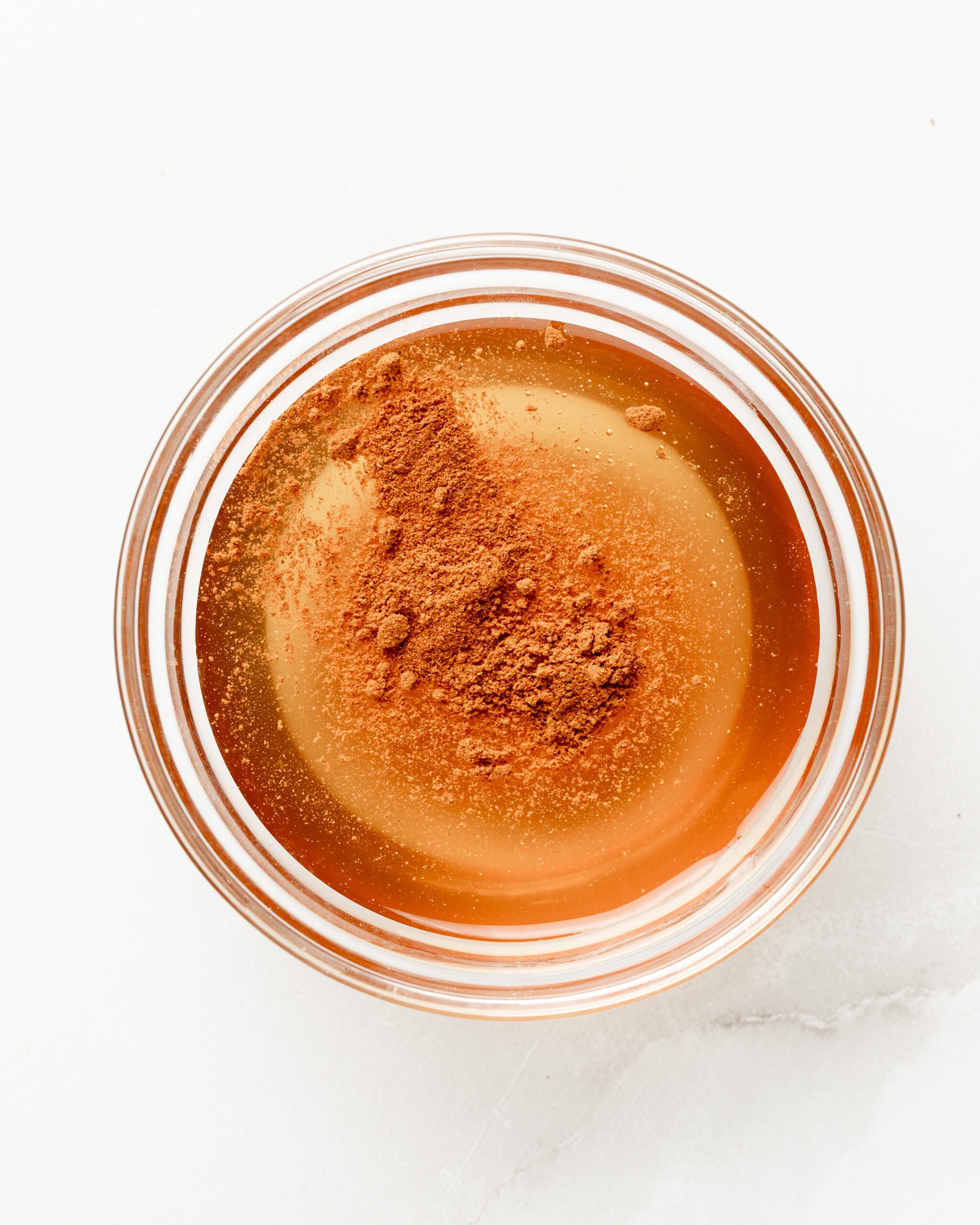 Honey in a small bowl with cayenne pepper.