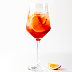 A photo of an Aperol Spritz with an orange wedge.