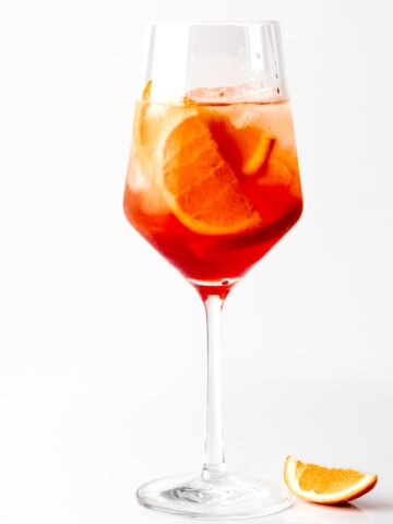 A photo of an Aperol Spritz with an orange wedge.