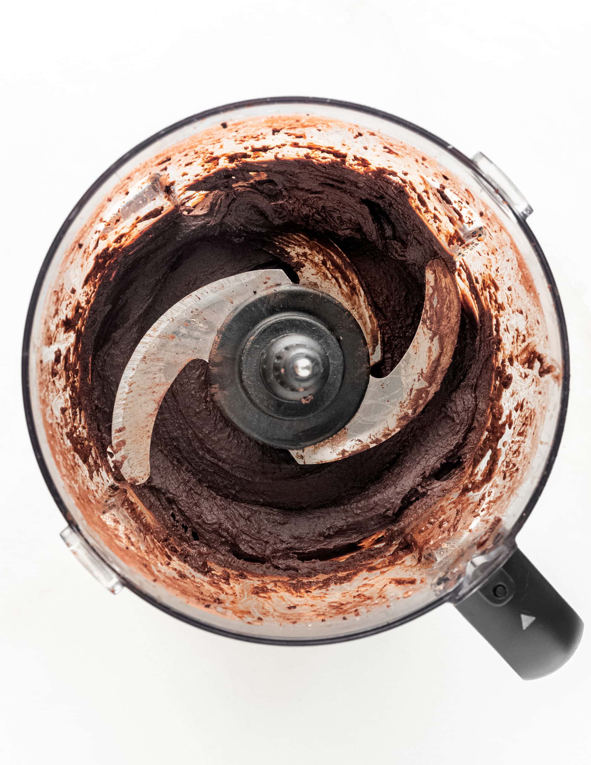 A food processor overhead shot with blended dark chocolate hummus.