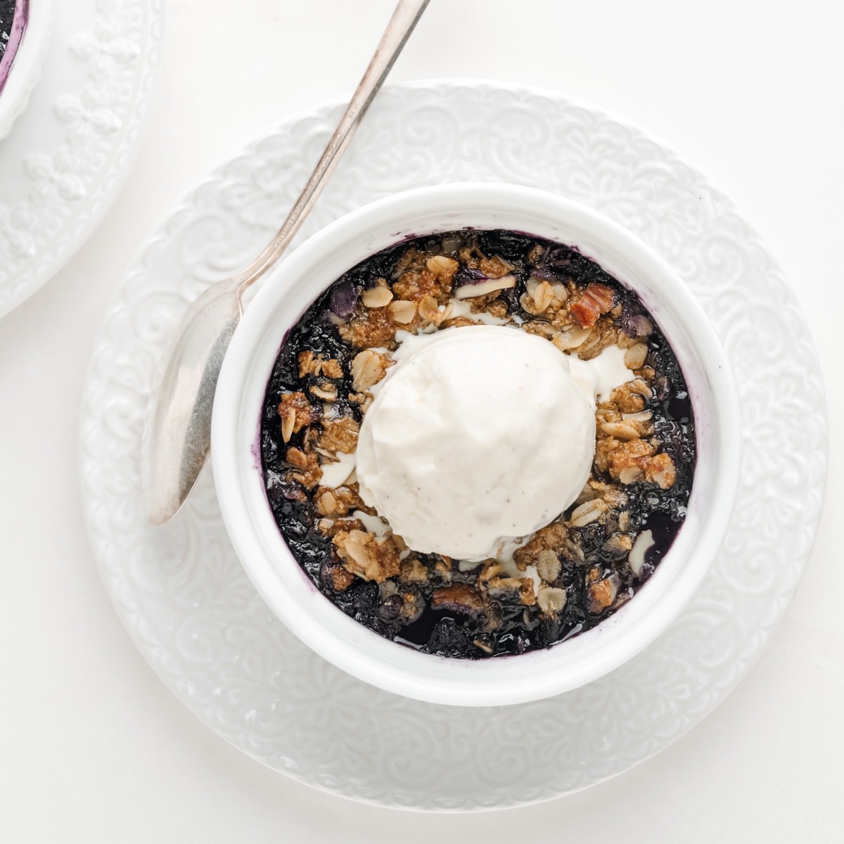 Blueberry crisp with a dollop of vanilla ice cream on top.