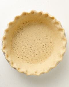 Flute the edges of pie crust and dock.