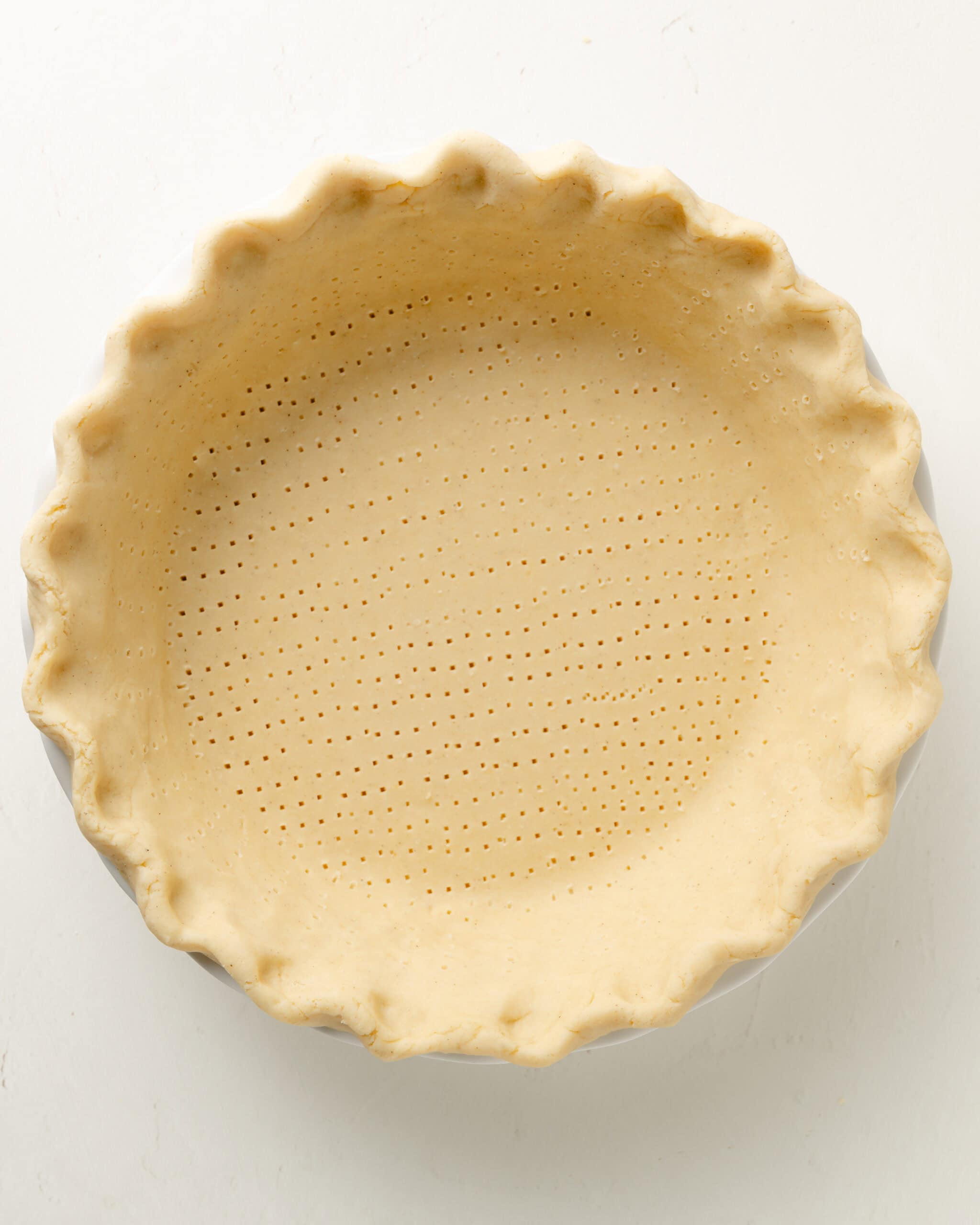 Flute the edges of pie crust and dock.