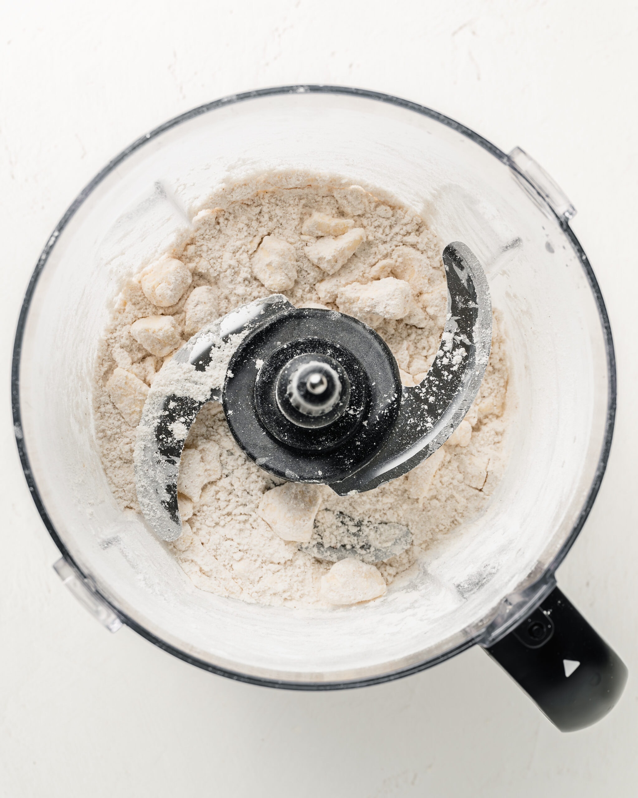 Adding the cold cubed butter to a food processor.