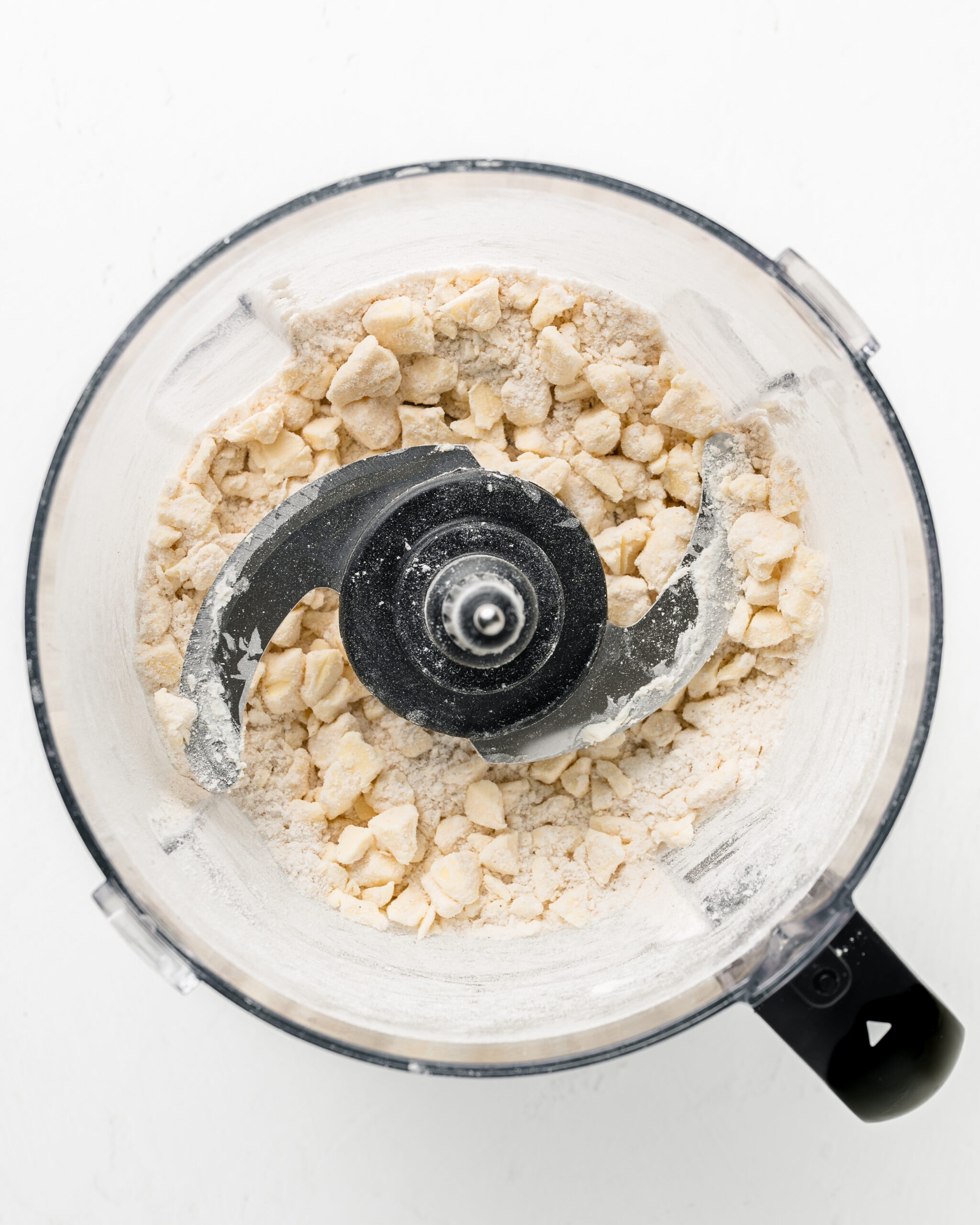 Adding sour cream to food processor for pie dough.