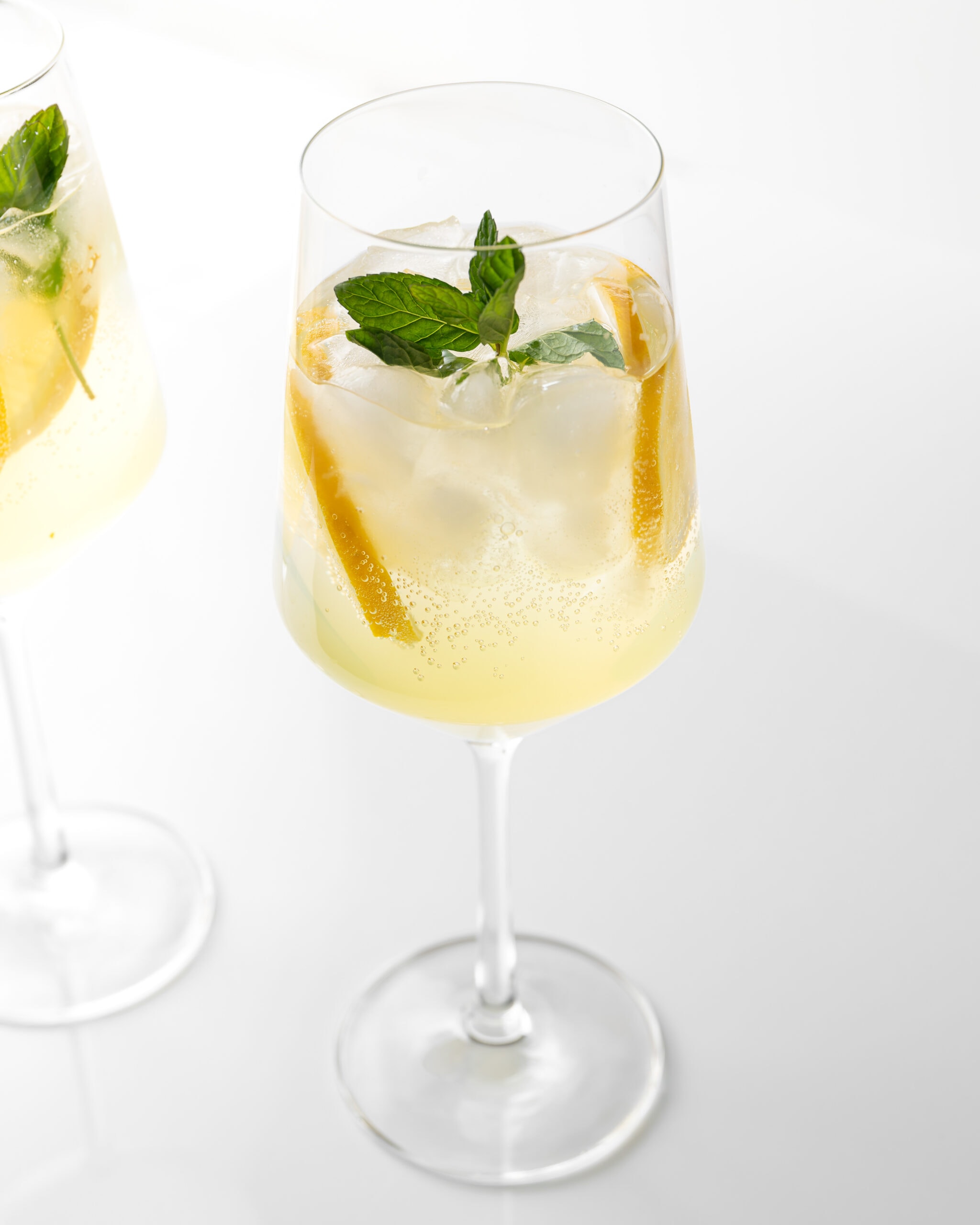 Limoncello spritz cocktail with bubbles, lemon slices, and mint.