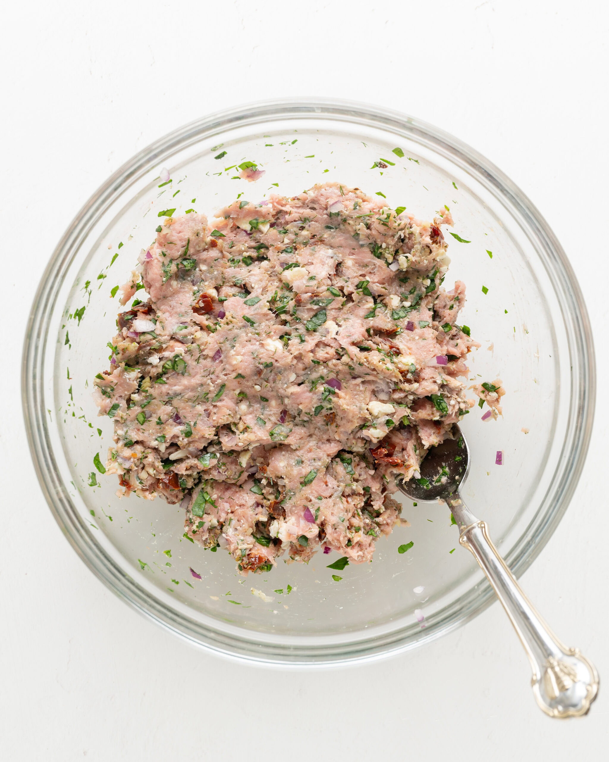 Mixing together the feta turkey burger ingredients.