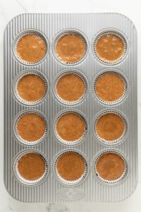 Carrot cake cupcakes divided into muffin tins.