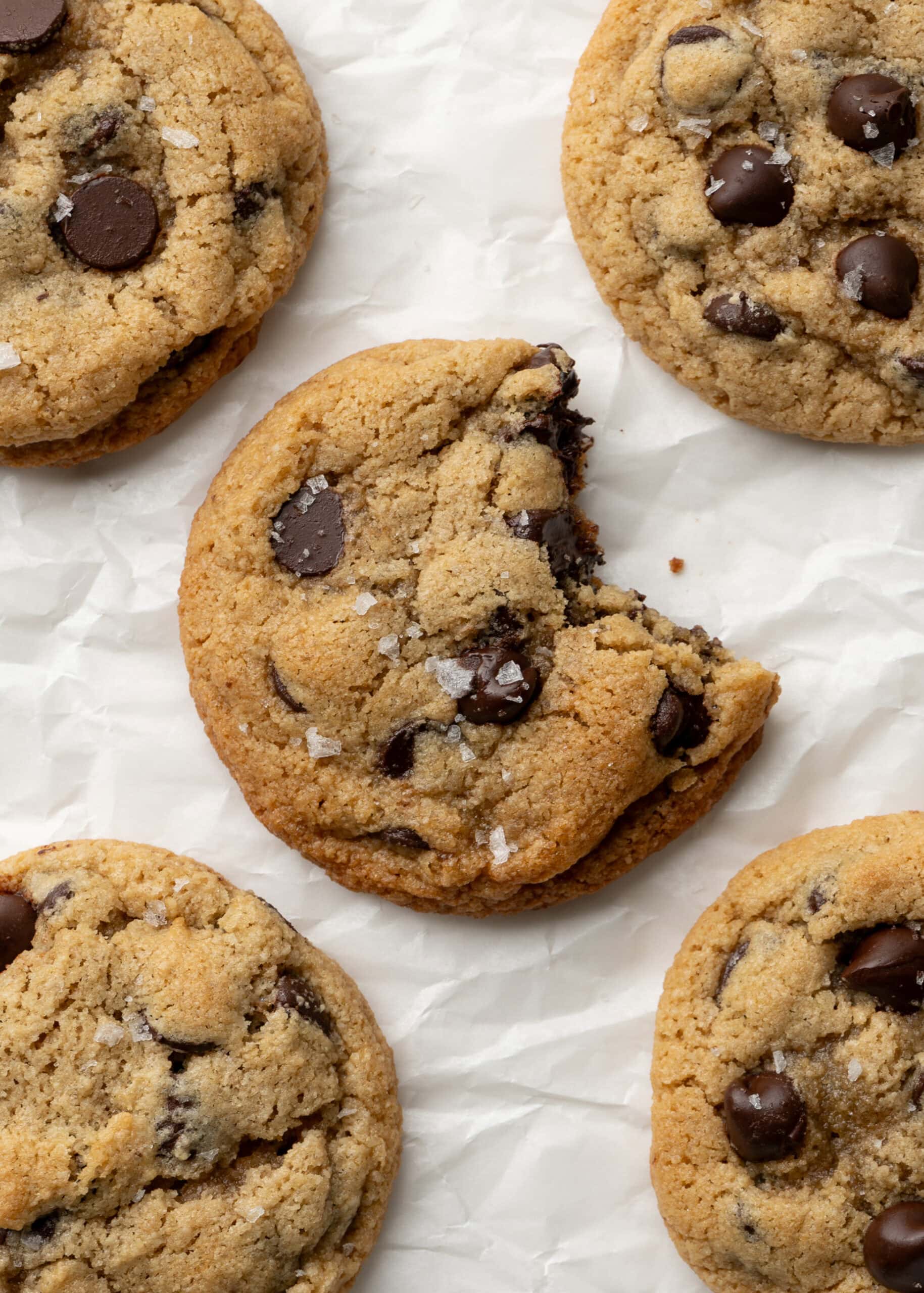 Almond flour cookies with chocolate chips. A bite is taken out of the center cookie exposing the melty chocolate chips.
