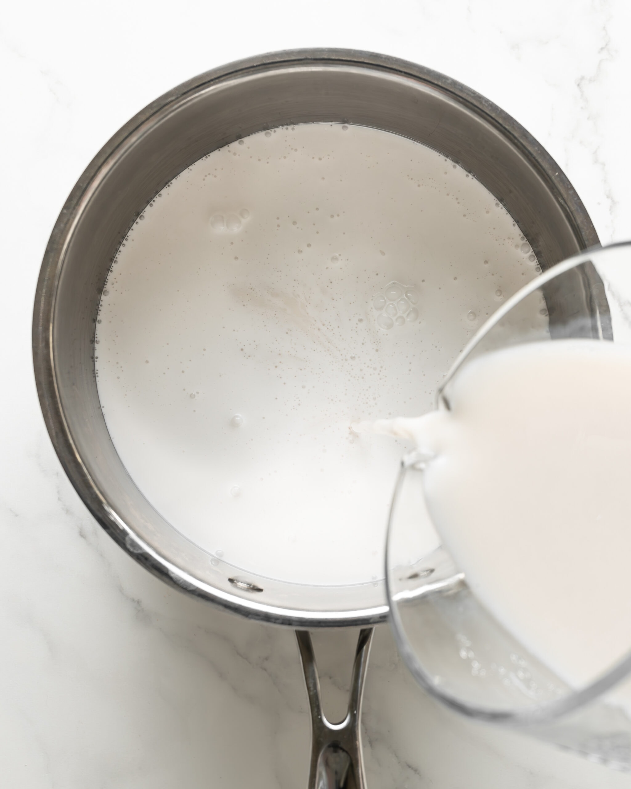 Adding milk to saucepan