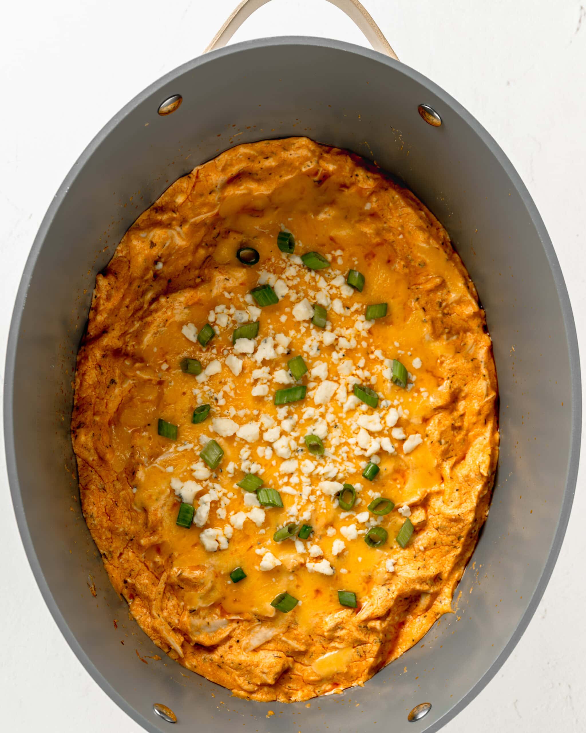 Melted cheese and green onion on buffalo chicken dip.