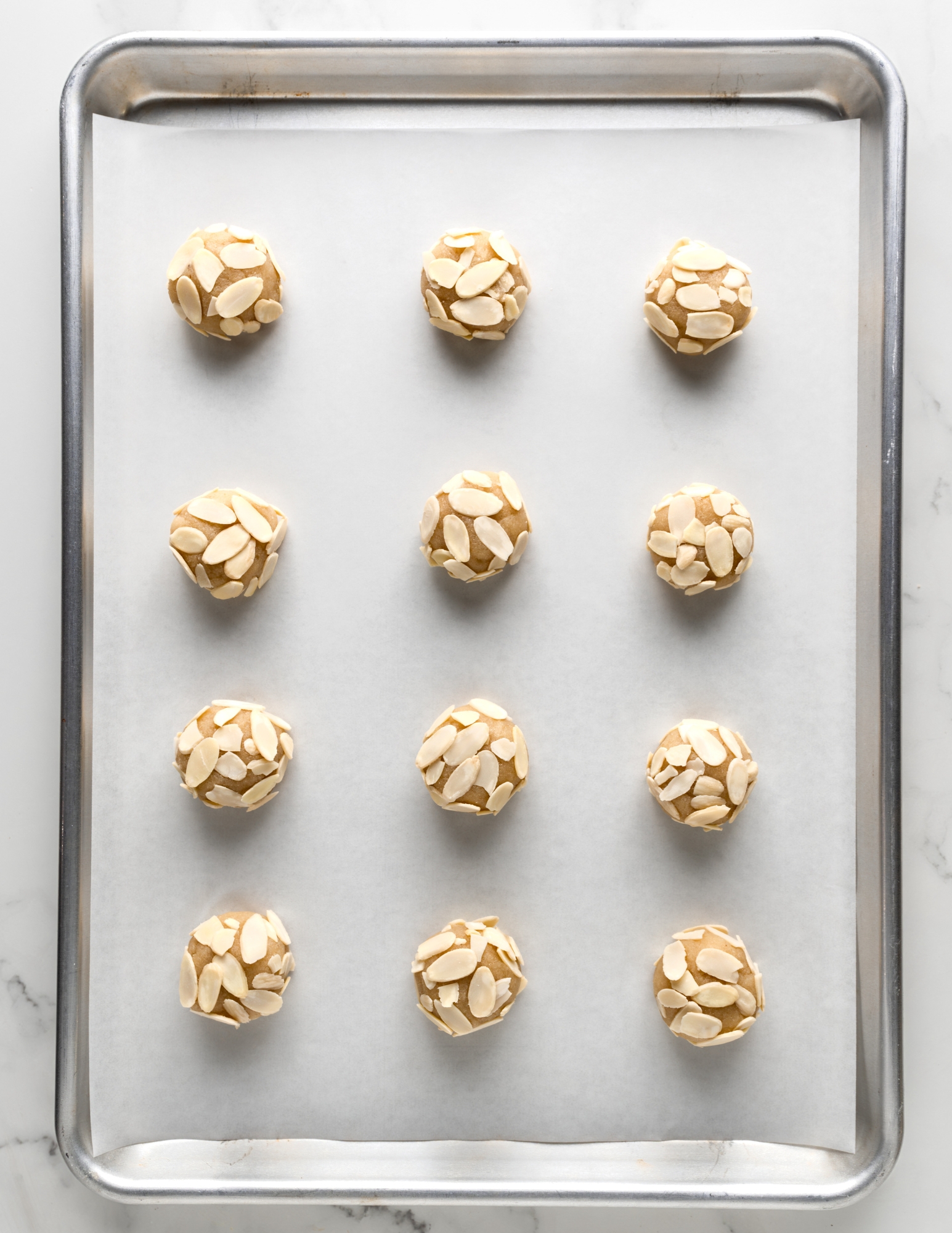 Amaretti Cookies on Baking Sheet covered in Almonds