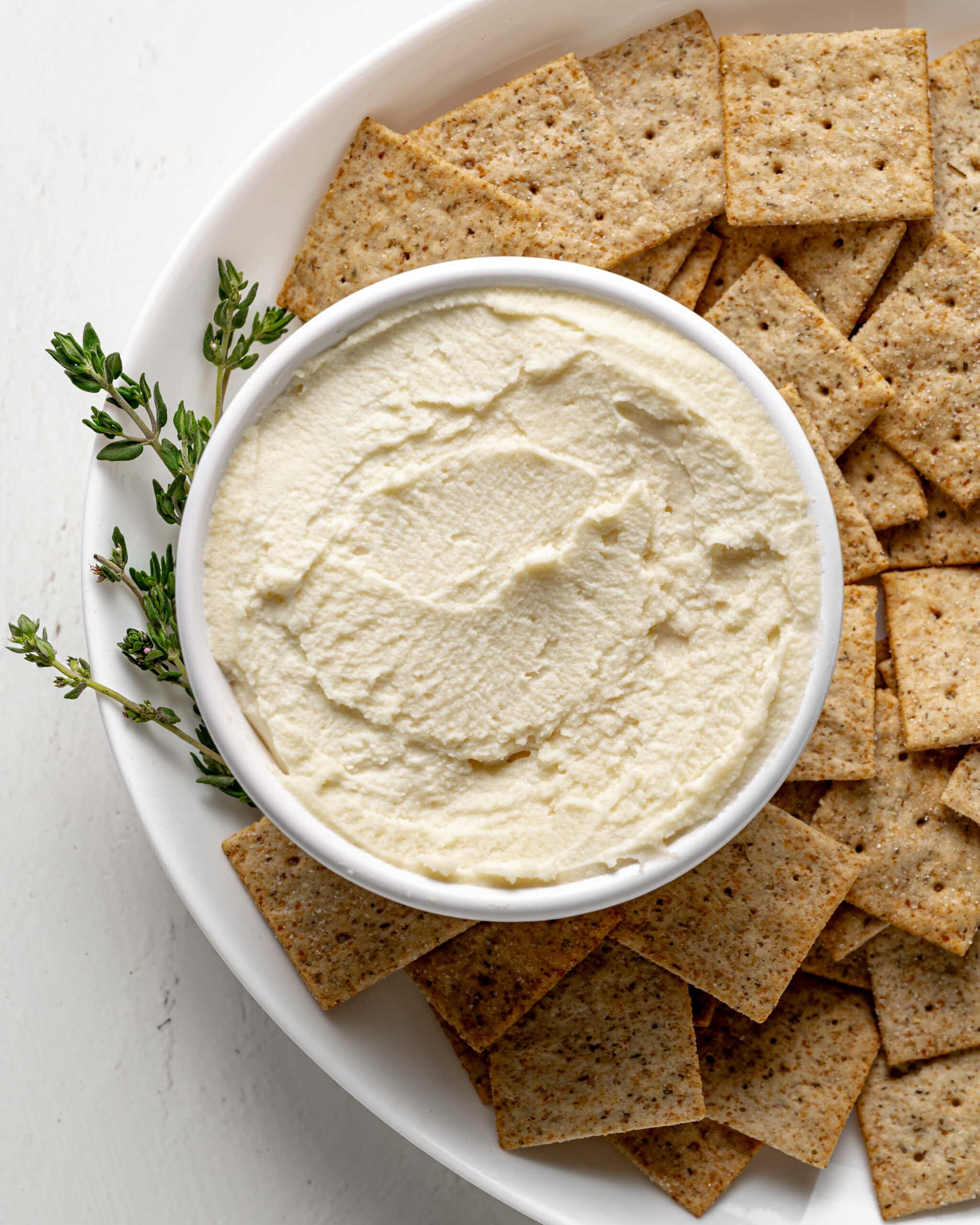 Mascarpone dip in a cup with crackers.