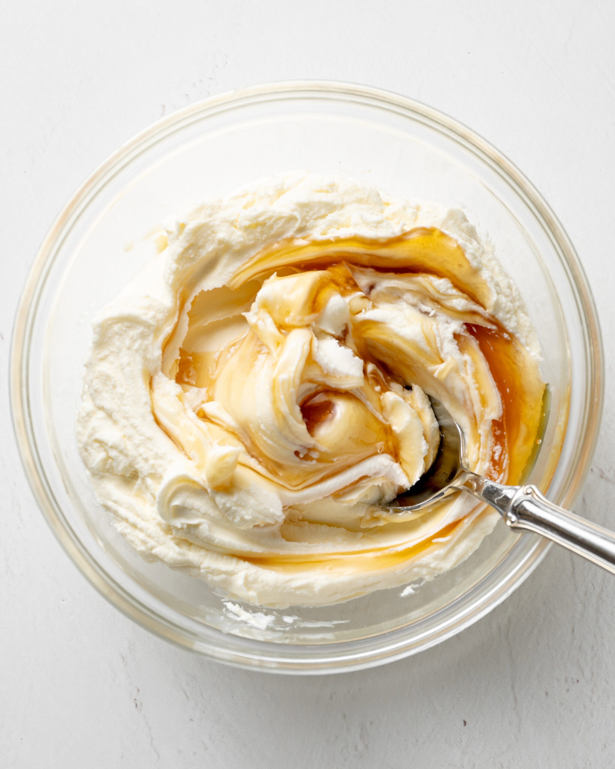 Bowl of mascarpone and honey being stirred.