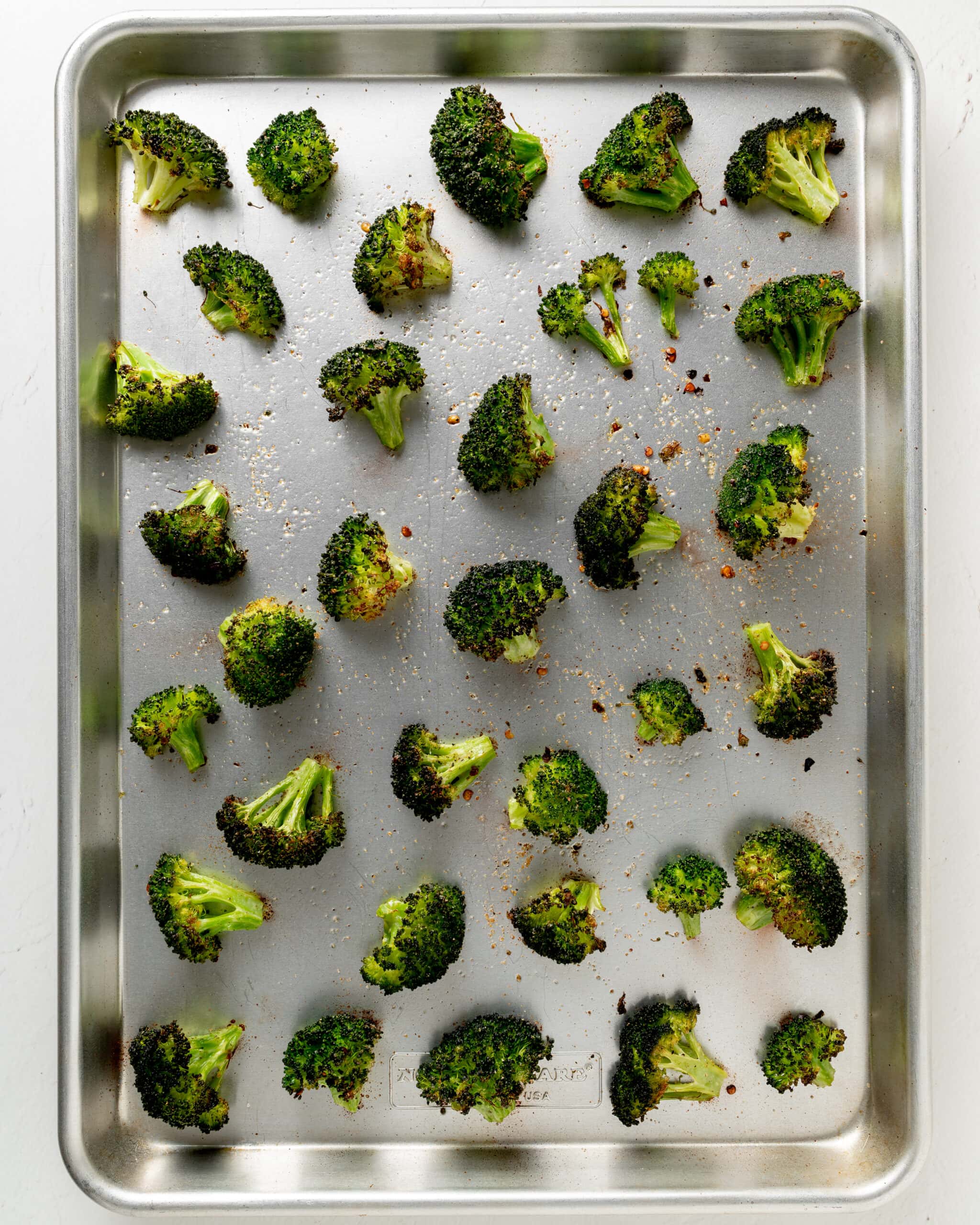 Broccoli cooked on a baking sheet until brown.