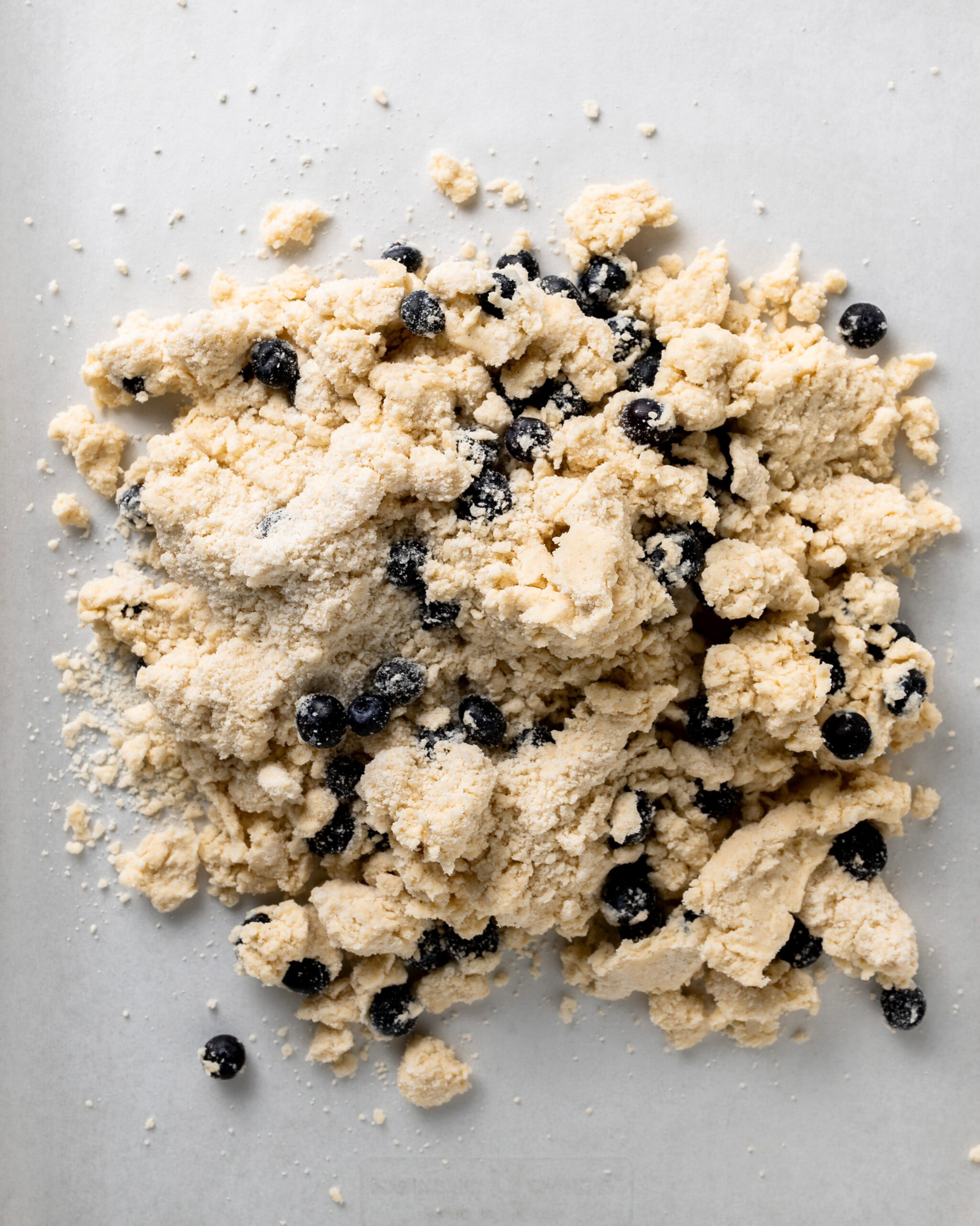 Blueberry scone dough being rolled out.