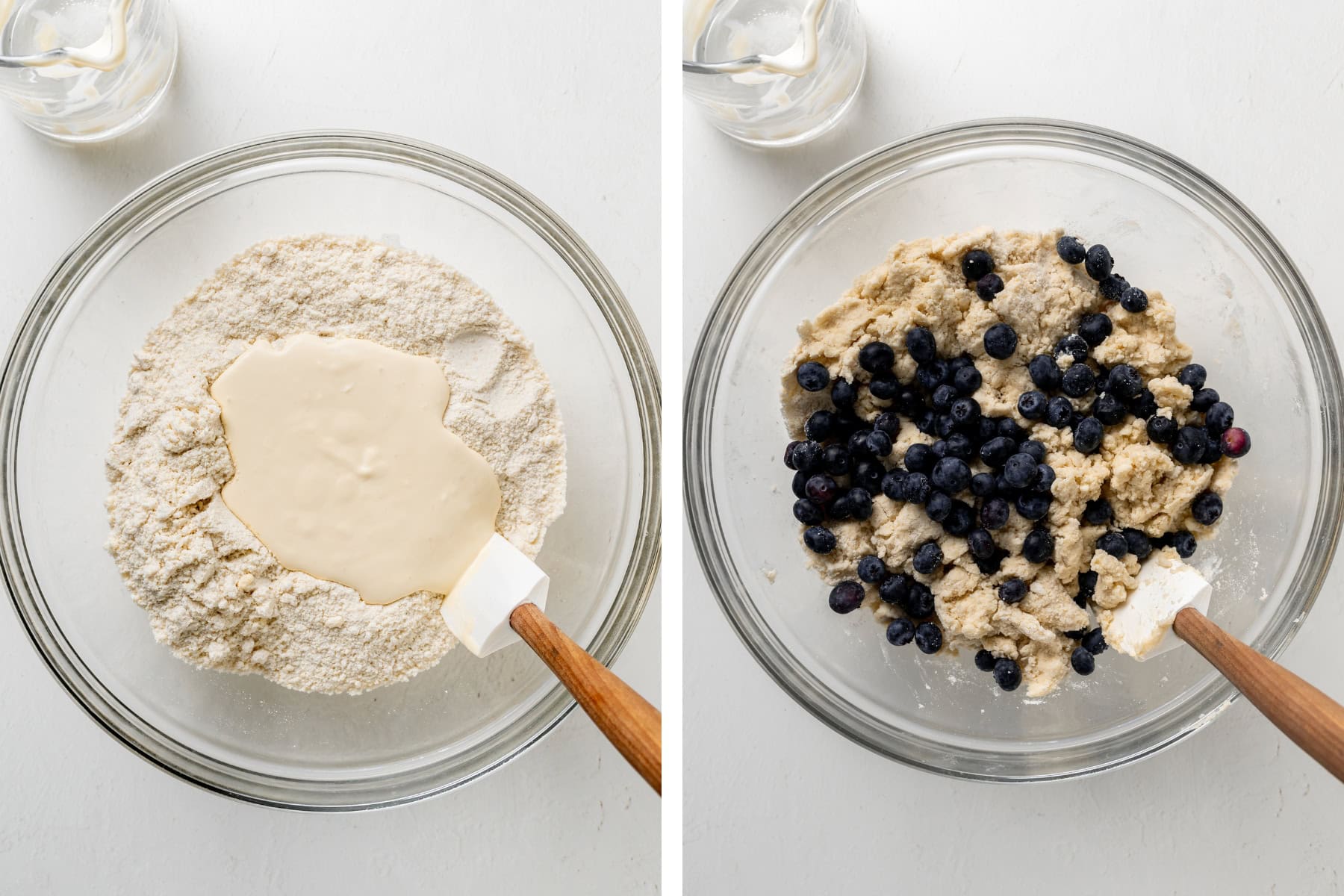 A large clear bowl with scone dough folding in blueberries.