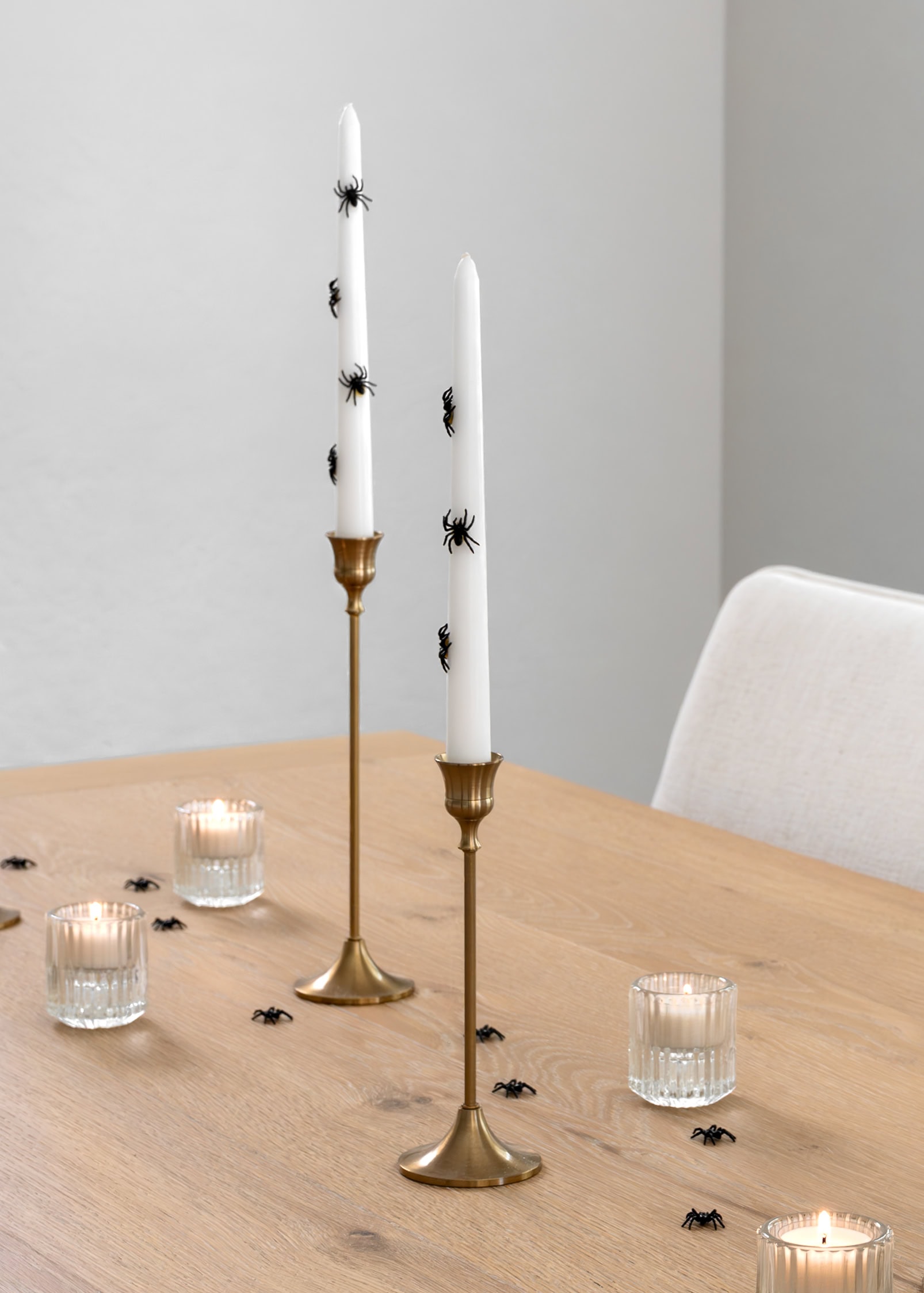 White candle sticks with black spiders.