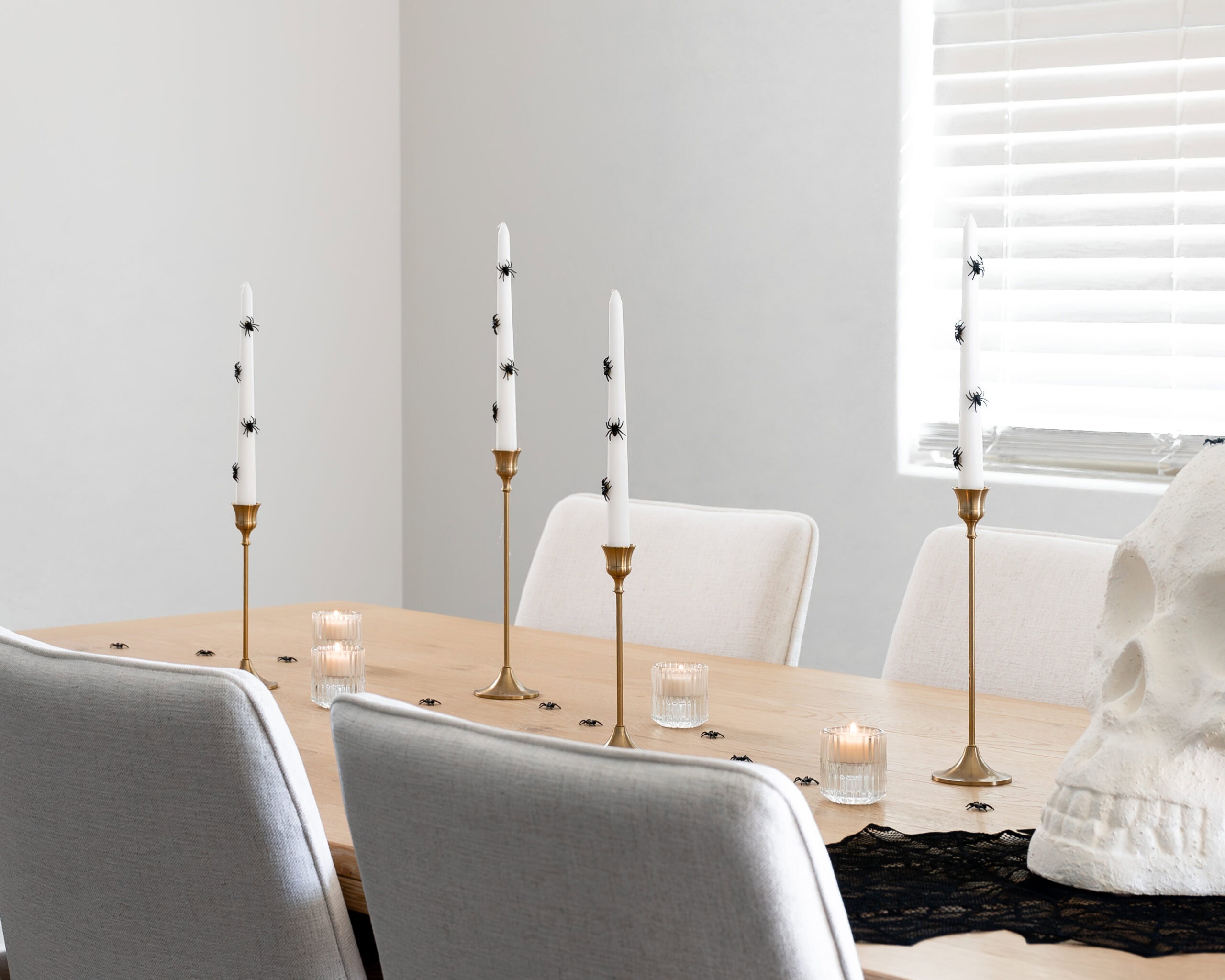 Halloween table with white spider candles and a skull wine bucket.