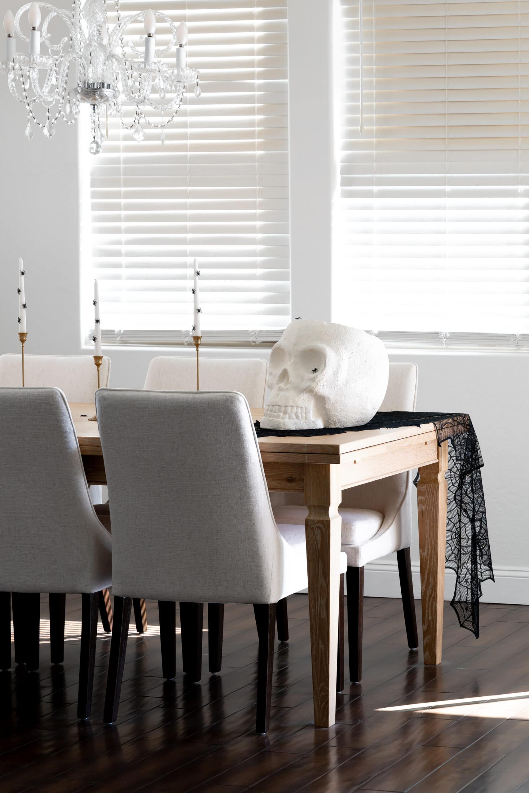 Halloween tablescape with candlesticks and white skull wine bucket.