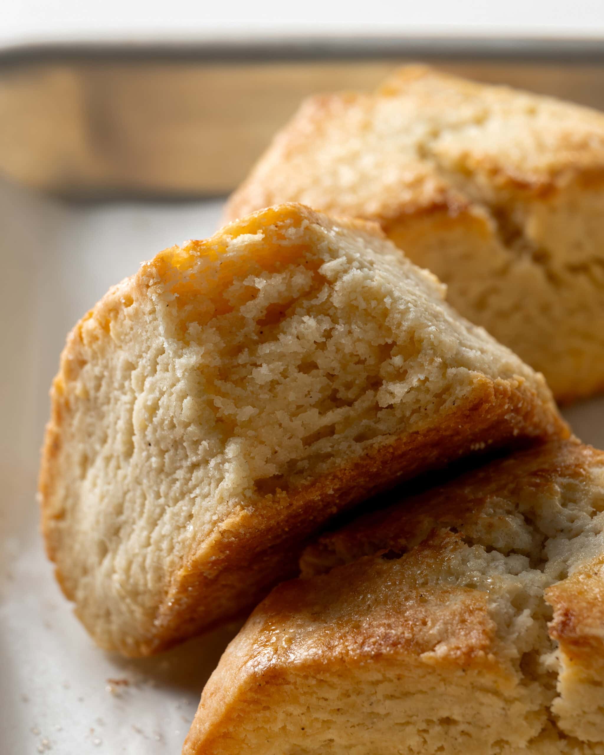 Up close photo of gluten free scone with the center exposed. The center is soft and fluffy with light crumbs and a golden brown exterior.