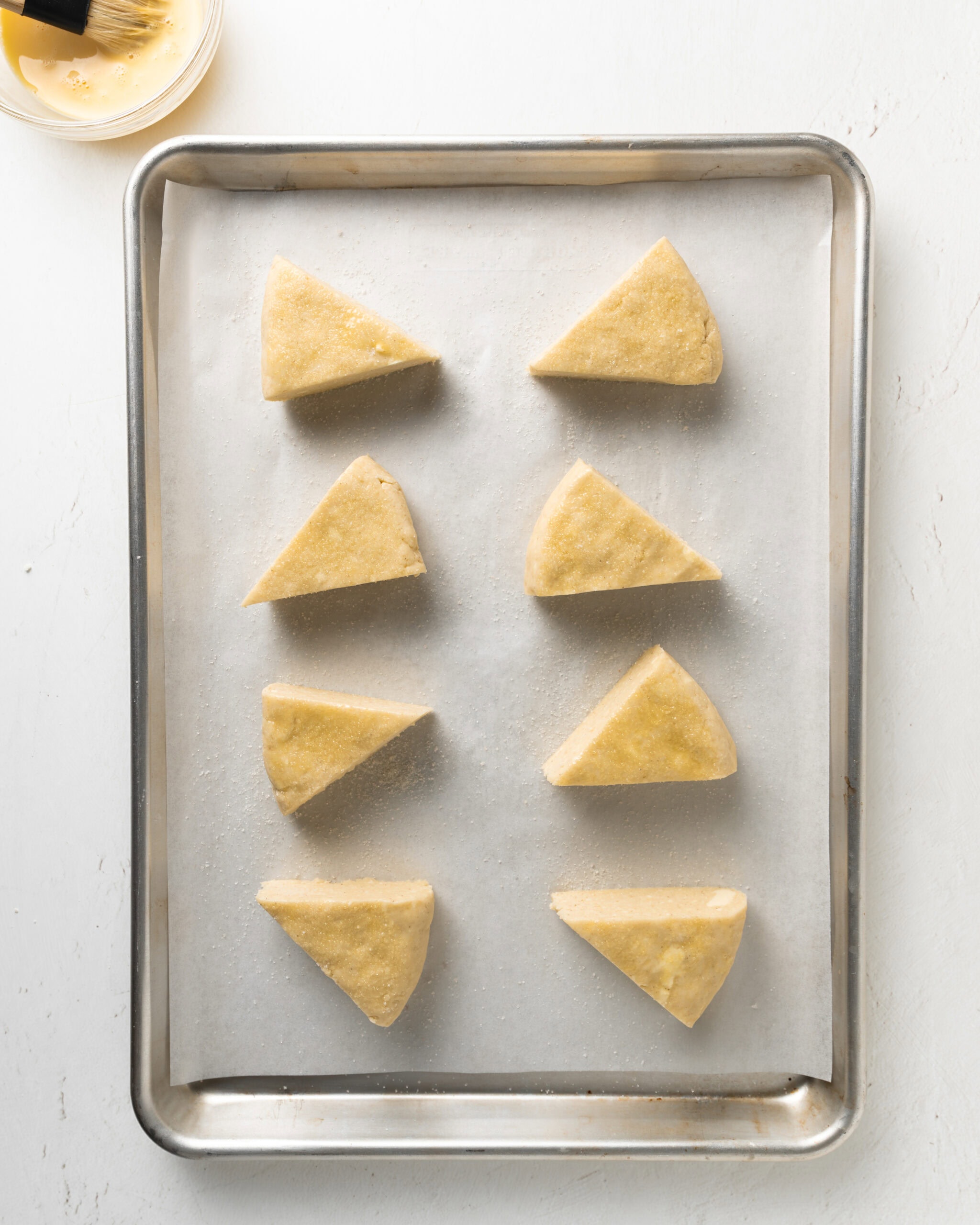 Plain scones on a large baking sheet.