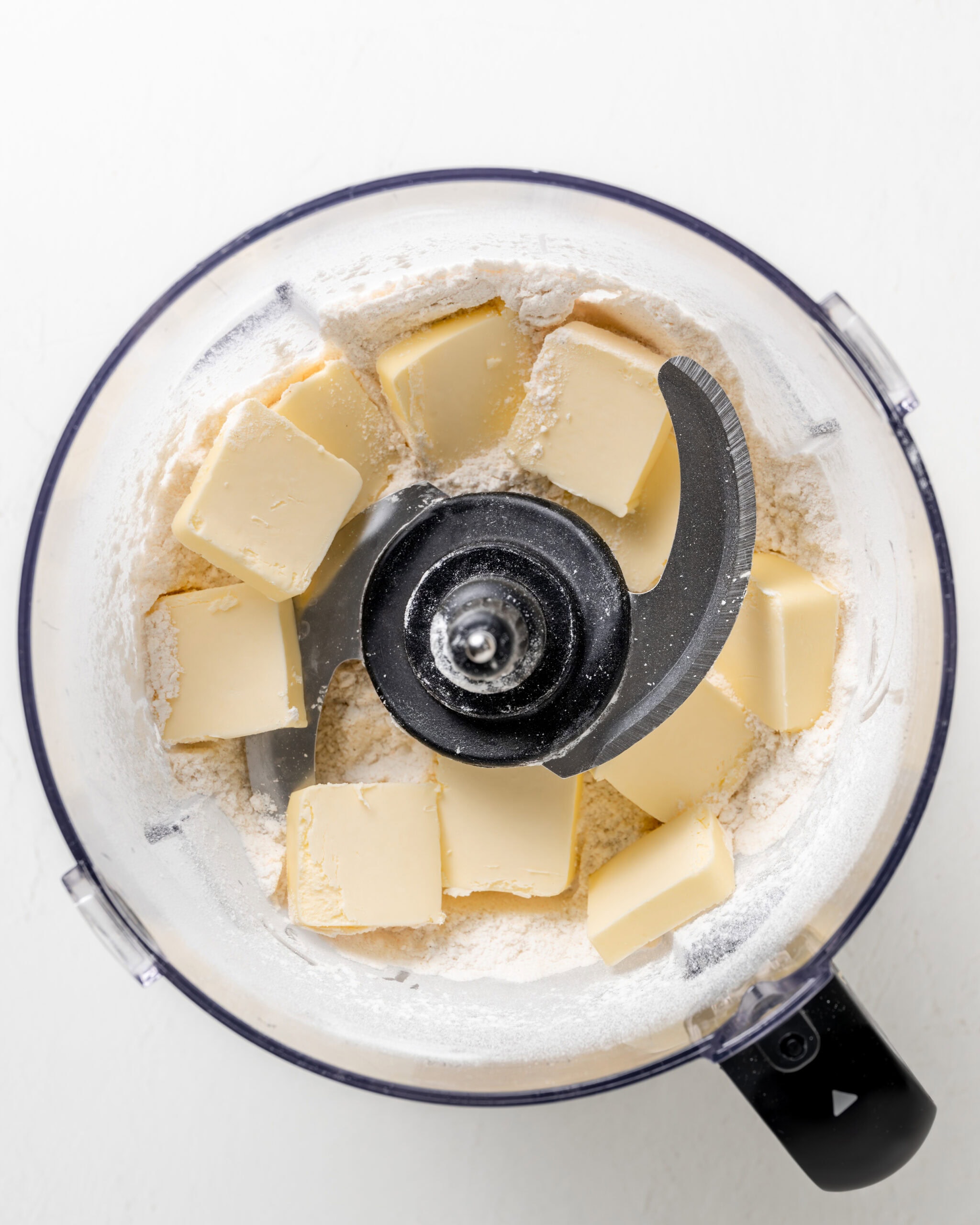 Butter inside a food processor with flour mixture.