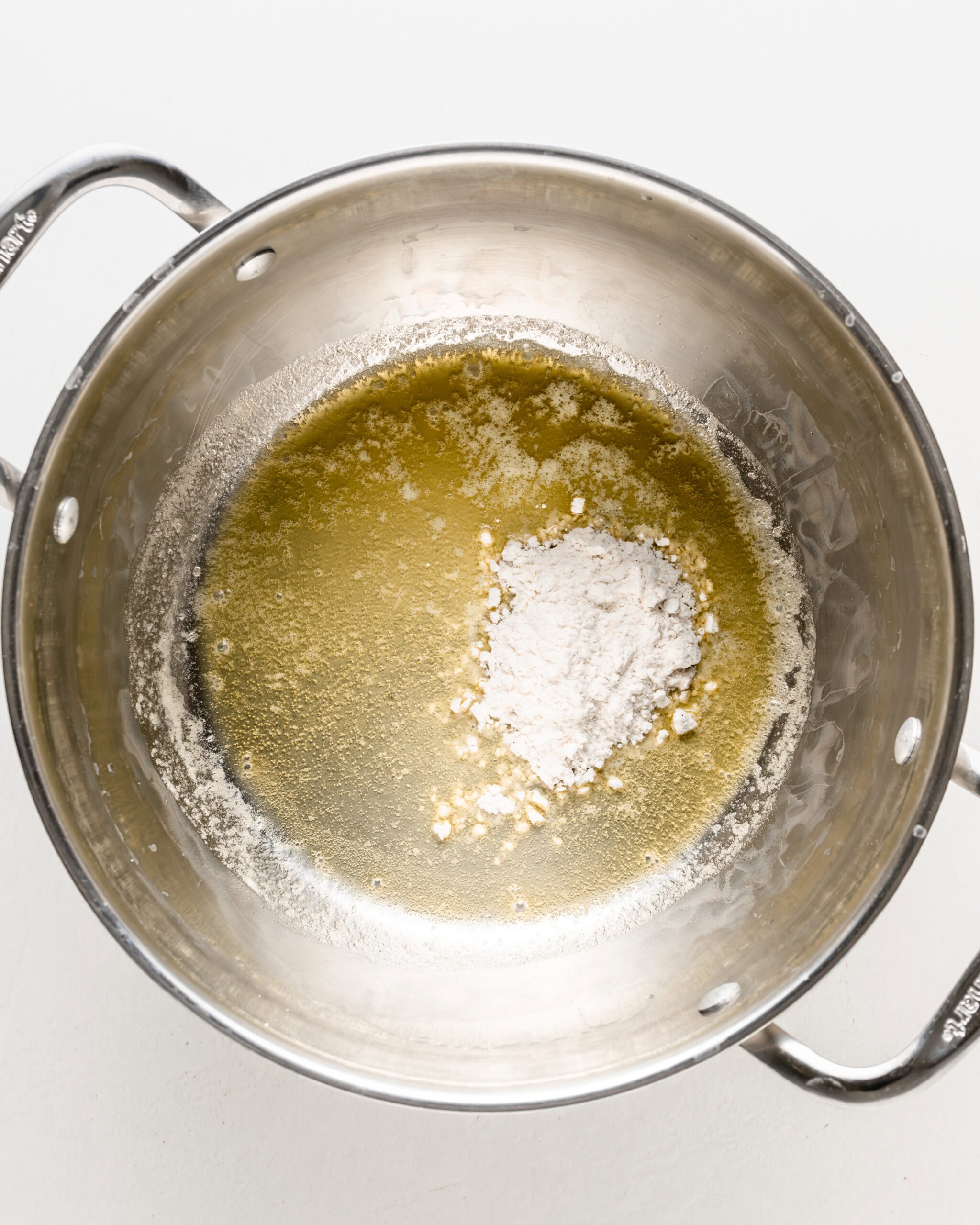 Making a roux in a large stainless steel pot.